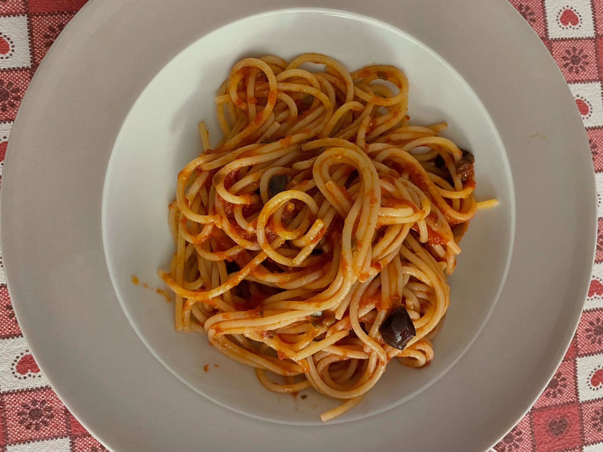 Ein Teller Spaghetti puttanesca von oben fotografiert