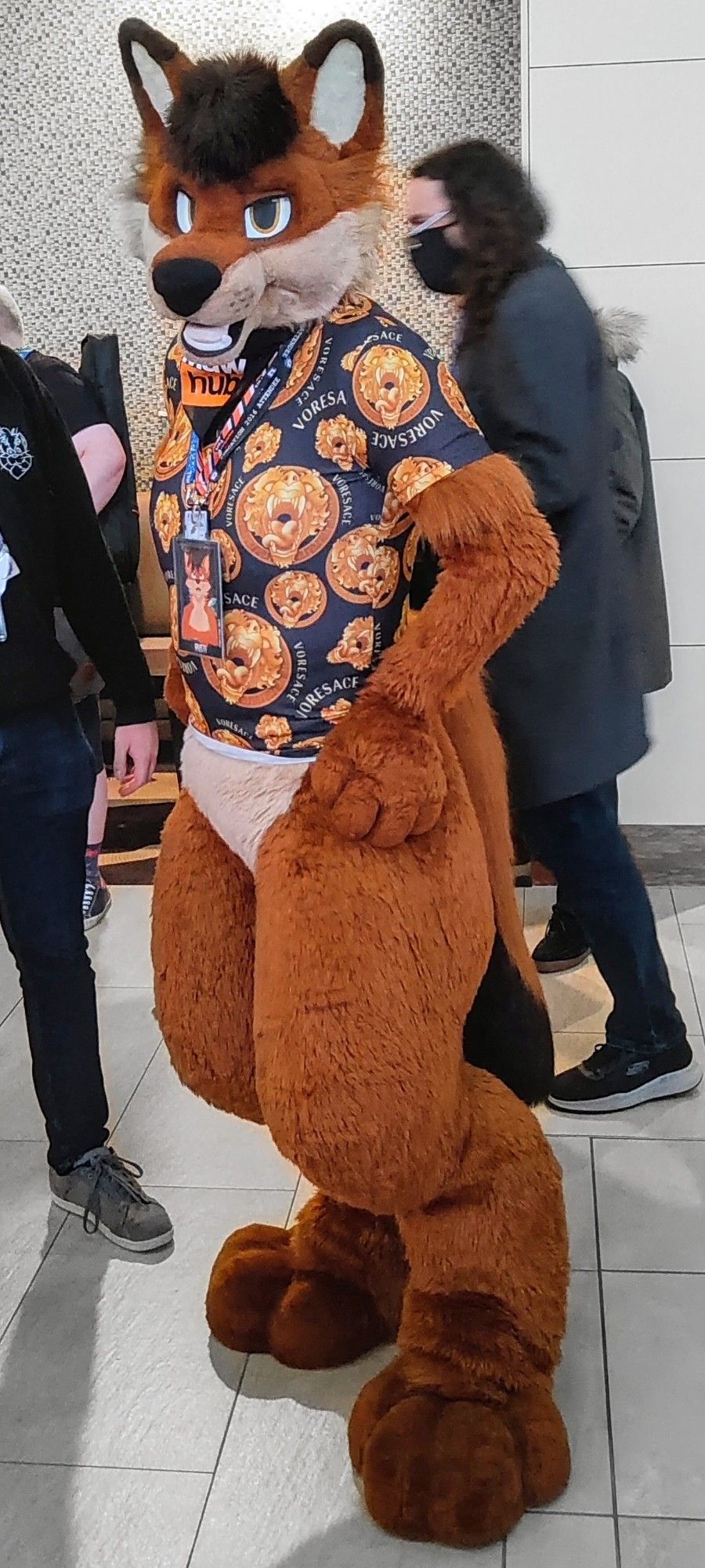 A dhole fursuit wearing a sassy "voresace" t-shirt, belonging to Rusti.