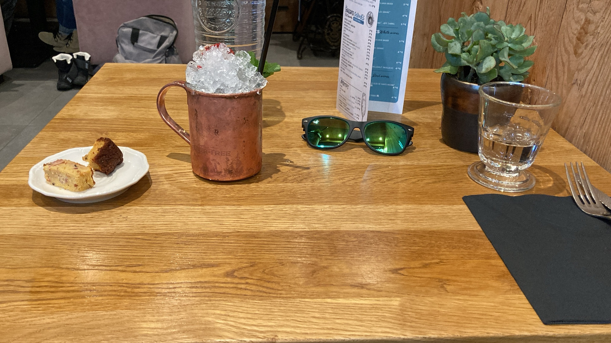 Table avec une tasse en métal de Moscow mule et assiette avec deux morceaux de quiche