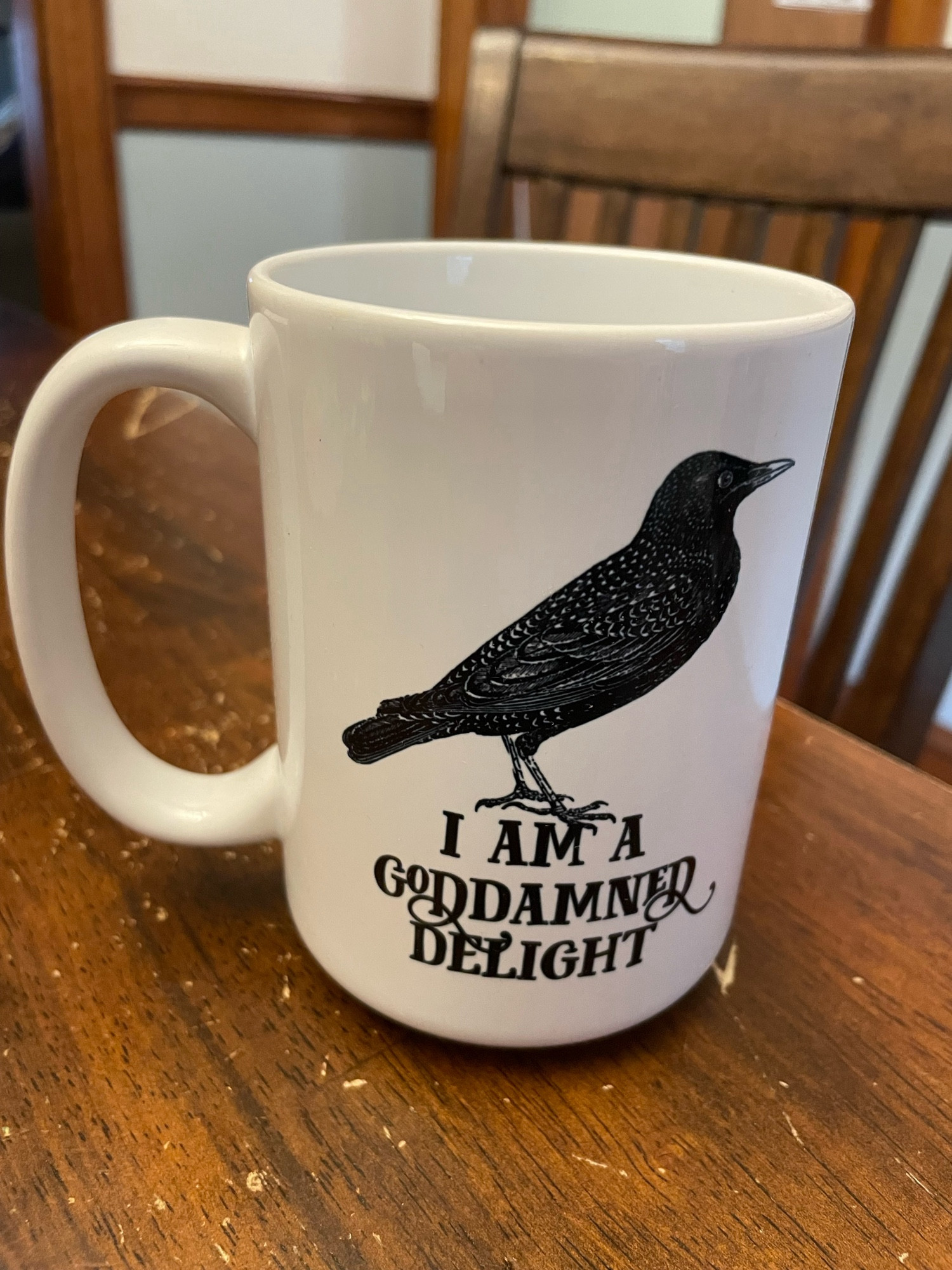 White coffee mug from EffinBirds on a brown table