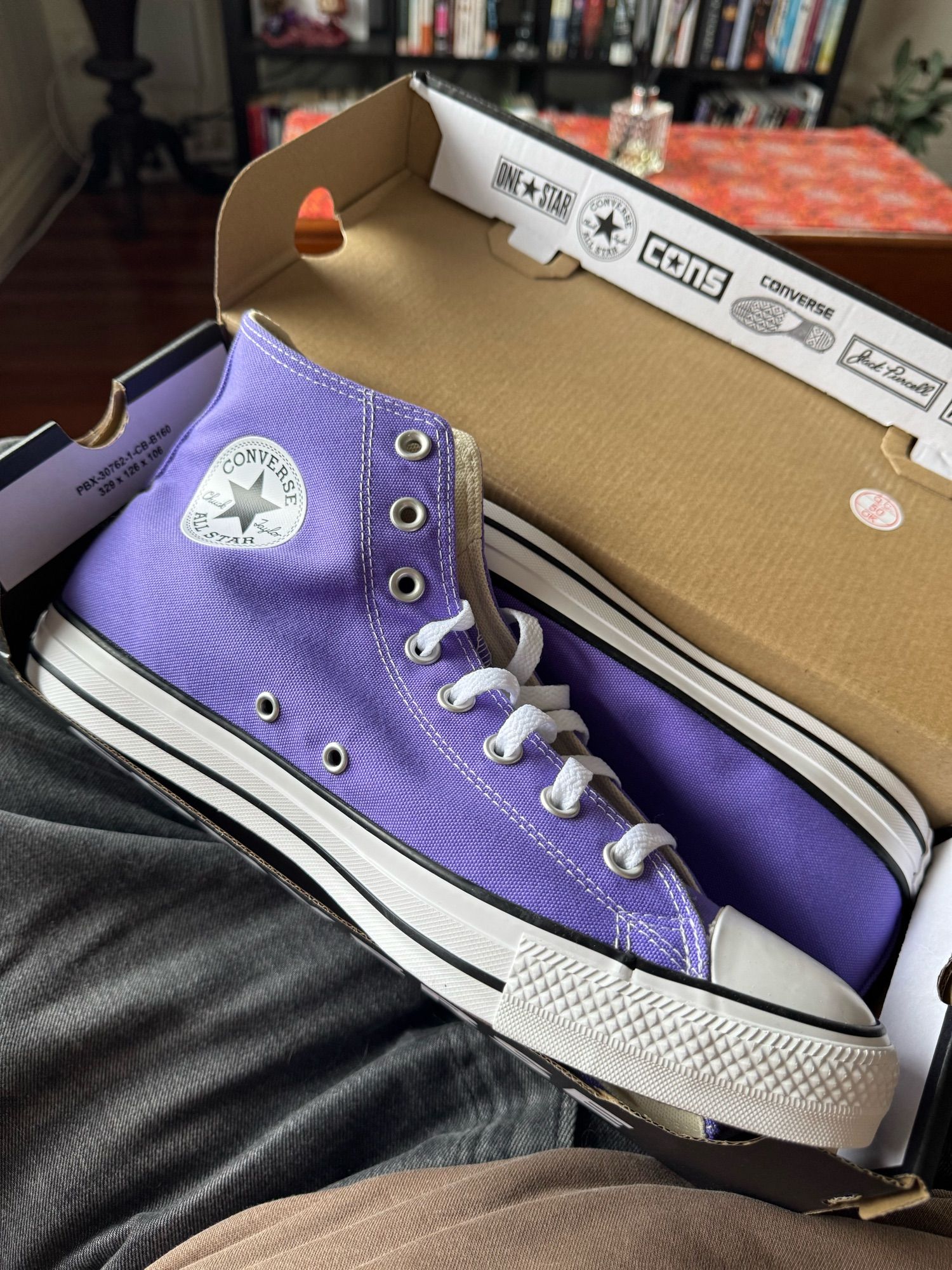 A pair of new in the box purple Converse high tops