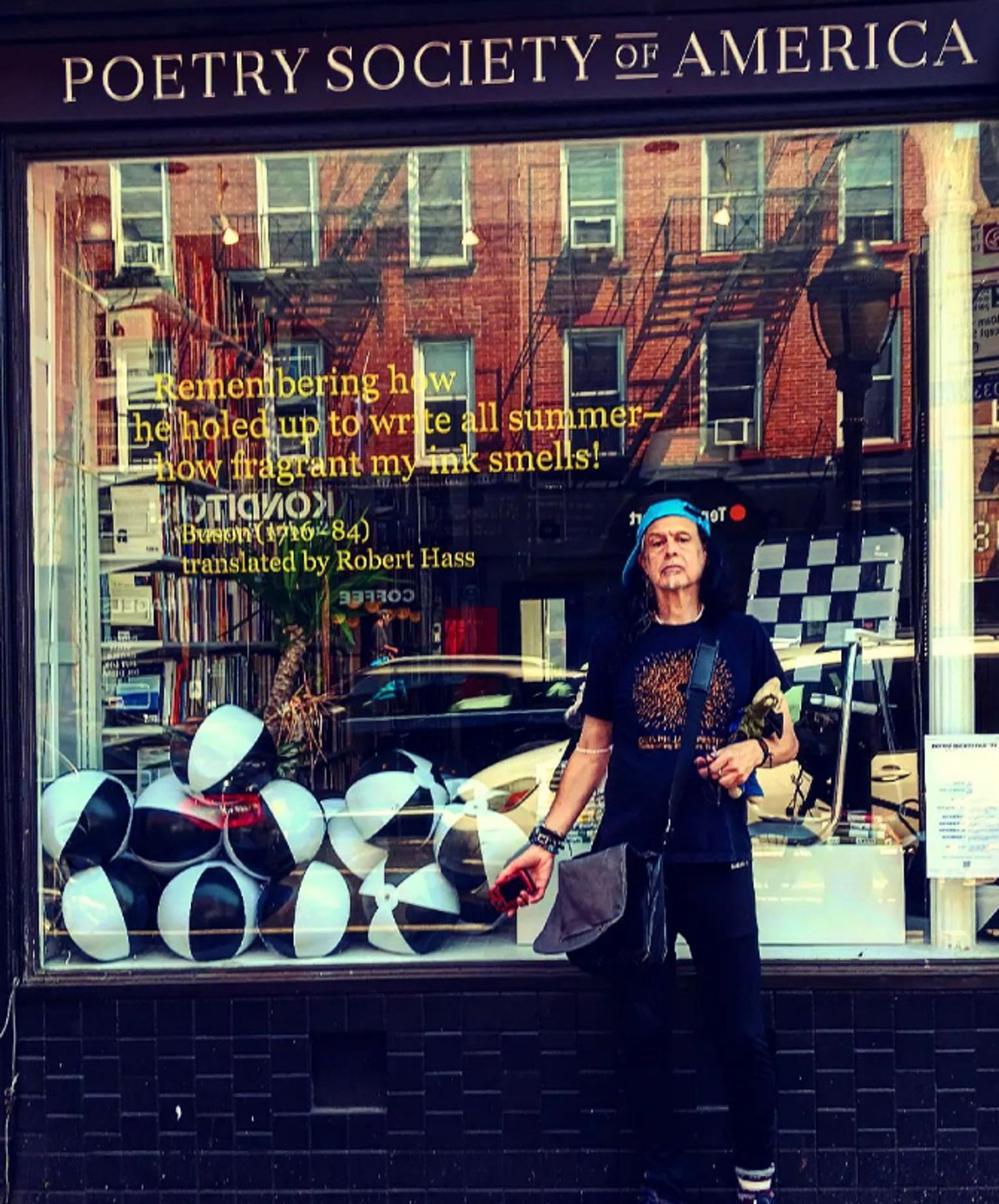 Our founder & EIC Robert in front of the Poetry Society Library in Brooklyn on Smith St. (near Pacific & Atlantic) Robert checking out the old hood.  A poem by Buson trans. by Robert Hass in the window. Reflection of apartment buildings, shop windows, the books in the library.