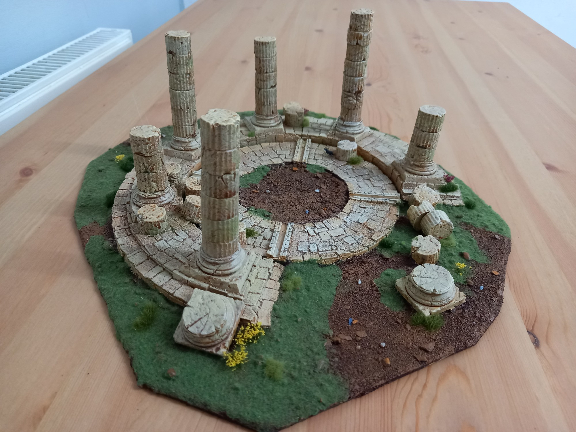 A wargaming model of a ruined Greek style temple.