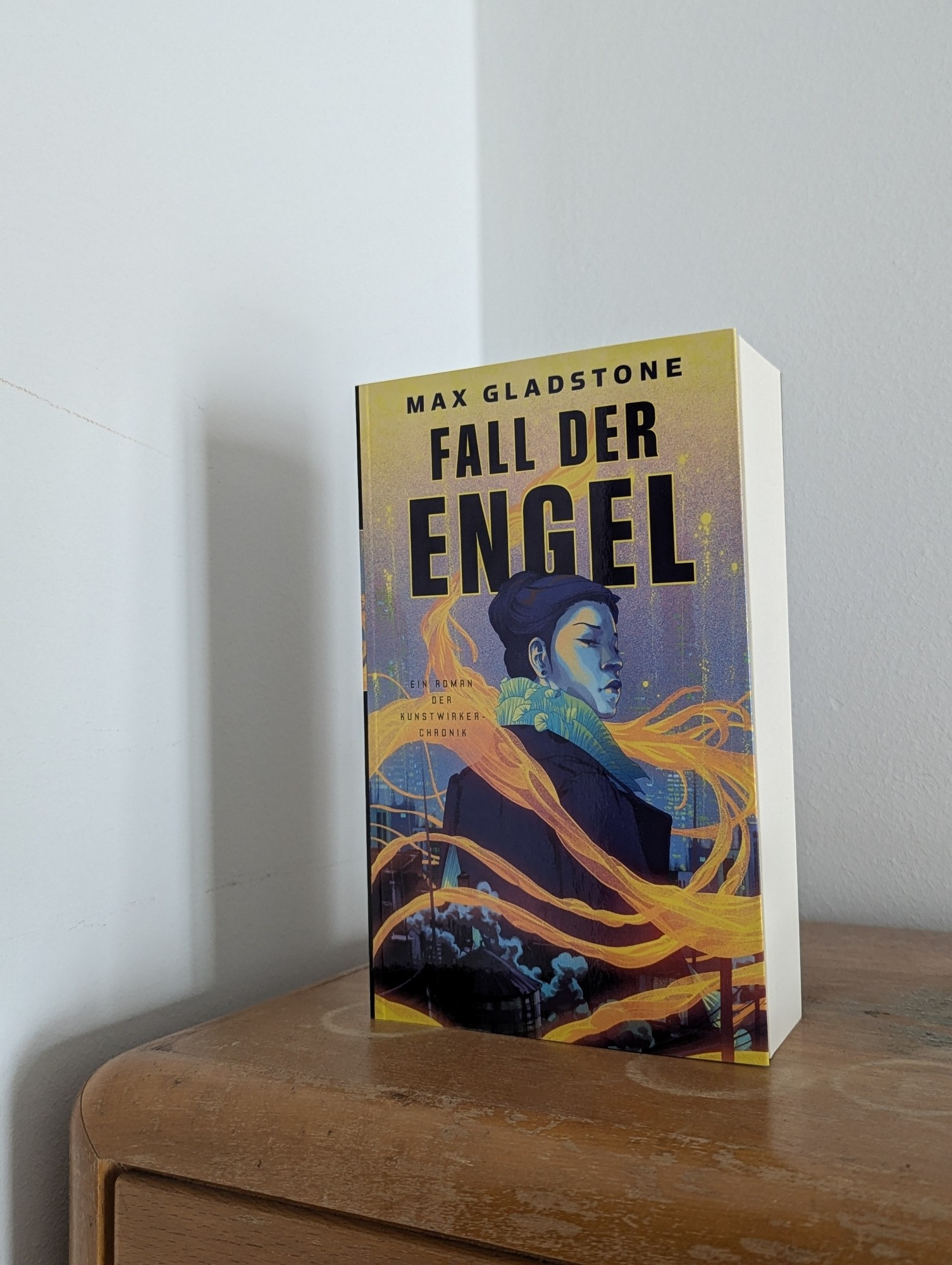 Das Buch "Fall der Engel" steht auf einem Schrank.