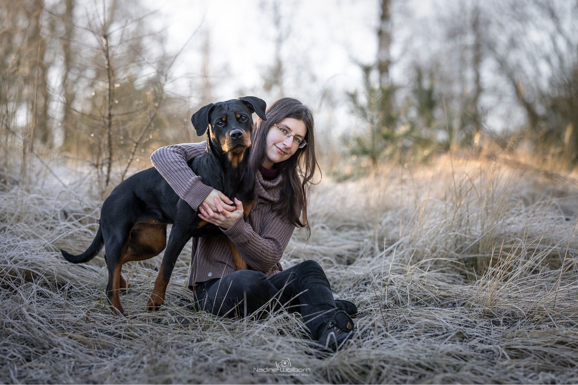 Bild von mir und einem Rottweiler im gefrorenen Gras sitzend