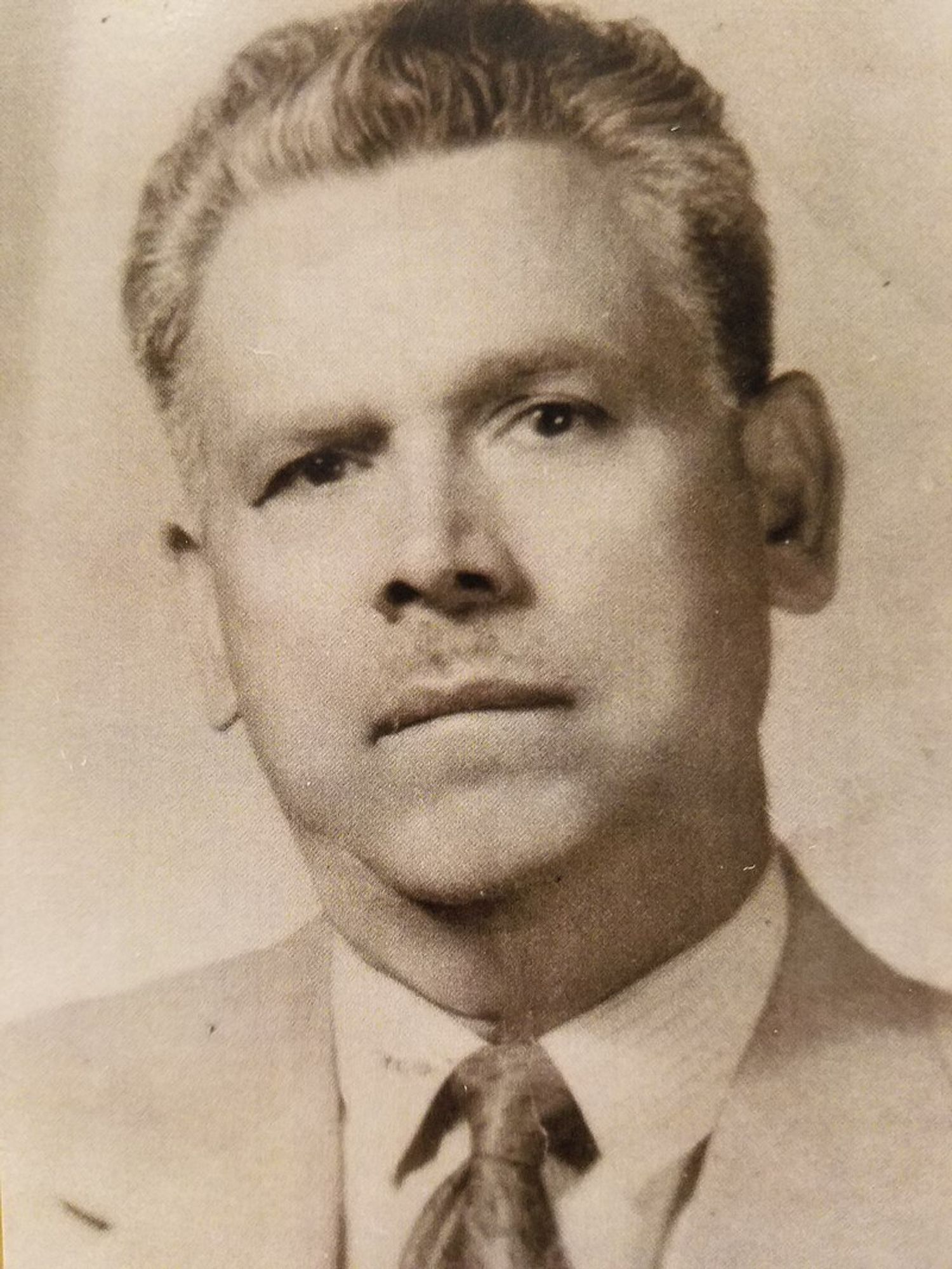 This is a headshot of Ignacio "Nacho" Anaya, the inventor of nachos.  He wears a suit, has salt and pepper hair, a slight mustache, and a blocky head with prominent ears.

"The person who took the photo is unknown, however Ignacio Anaya was the person who purchased it. Luis Ignacio Anaya inherited it after his grandfather's death. - This files came from Luis Ignacio Anaya, the grandson of Ignacio Anaya. He is the owner of the file and gives Wikimedia permission to use it."