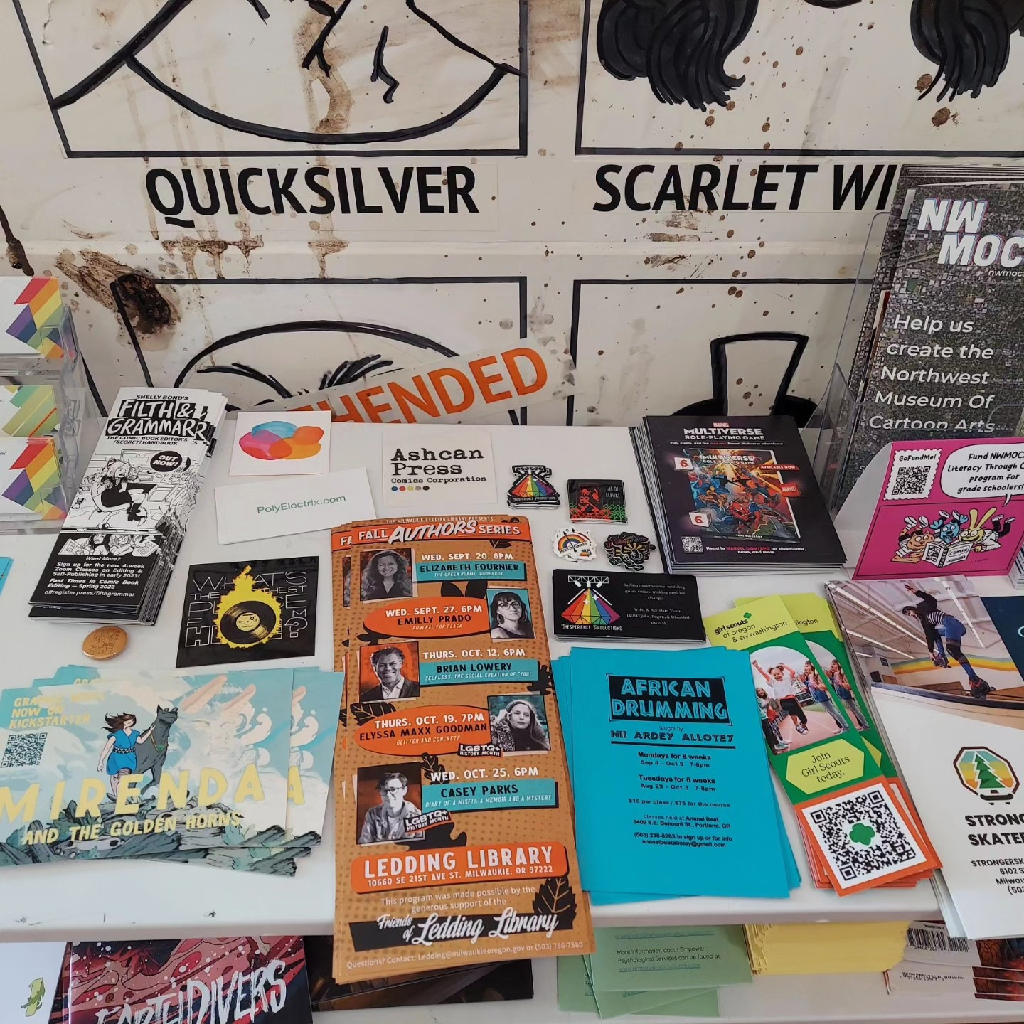 A zoomed out version of the previous photo, showing the other flyers on the table for nerdy and literary events.