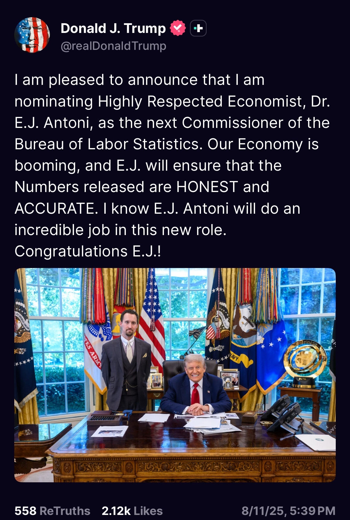 screenshot shows a photo of Trump smiling like a cheshire cat while sitting at the resolute desk while a younger man with round eyes stands next to him with his arms behind his back. The text of the truth social post it goes with says: Donald J. Trump
@realDonald Trump
I am pleased to announce that l am nominating Highly Respected Economist, Dr.
E.J. Antoni, as the next Commissioner of the Bureau of Labor Statistics. Our Economy is booming, and E.J. will ensure that the Numbers released are HONEST and ACCURATE. I know E.J. Antoni will do an incredible job in this new role.
Congratulations E.J.!
558 ReTruths
2.12k Likes
8/11/25, 5:39 PM
