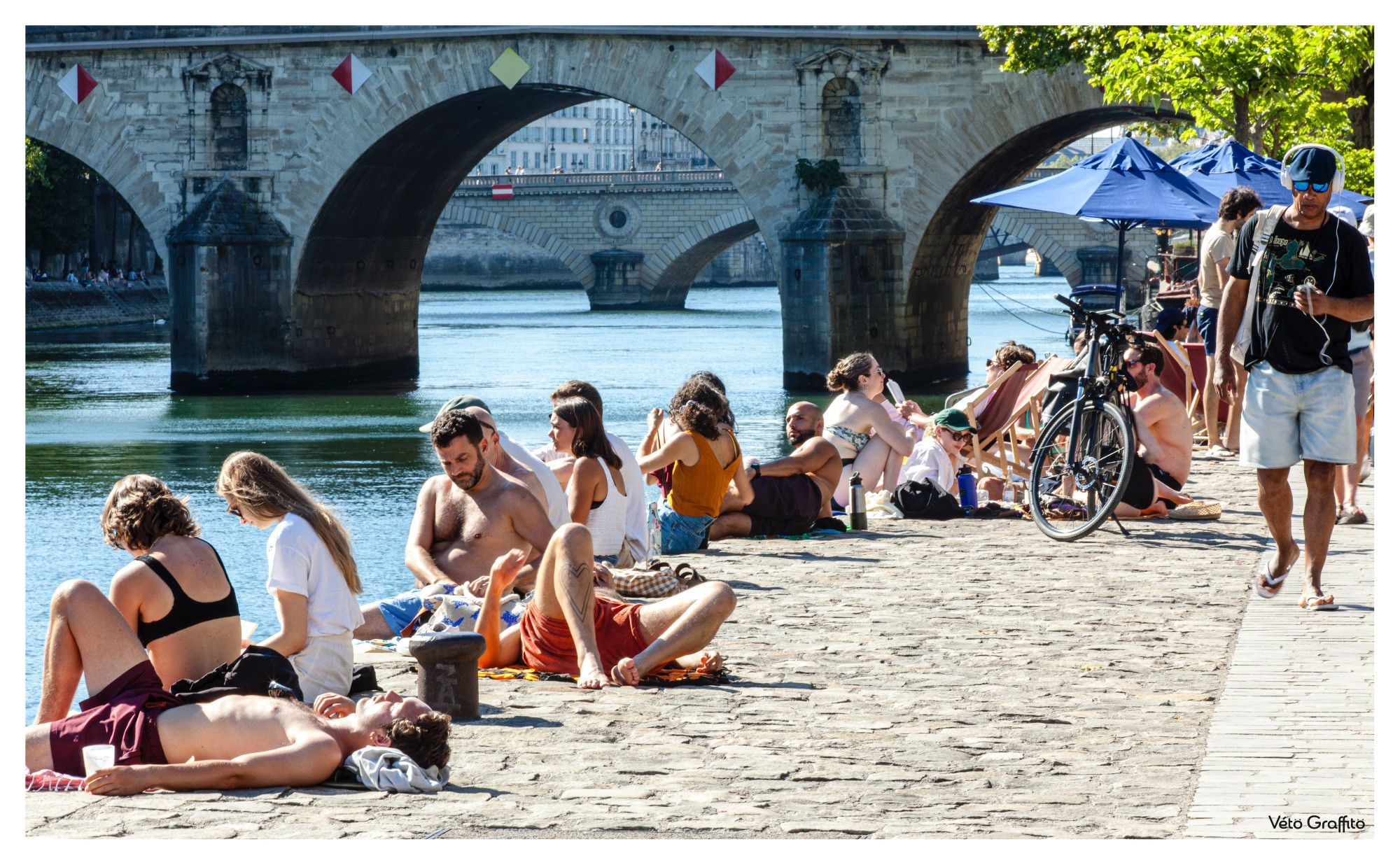 Bon, je peux l'avouer... ça ne vaut pas la plage de la Baule. Mais les gens retrouvent d'instinct les réflexes pour se prélasser, bronzer, pique-niquer, discuter face aux îles de la Cité, de Saint-Louis. Bref, profiter d'un droit dominical légitime à la paresse. Seul manque le vendeur ambulant qui s'époumonerait à clamer ses chichis, glaces, esssssquimaux !

© Vétograffito