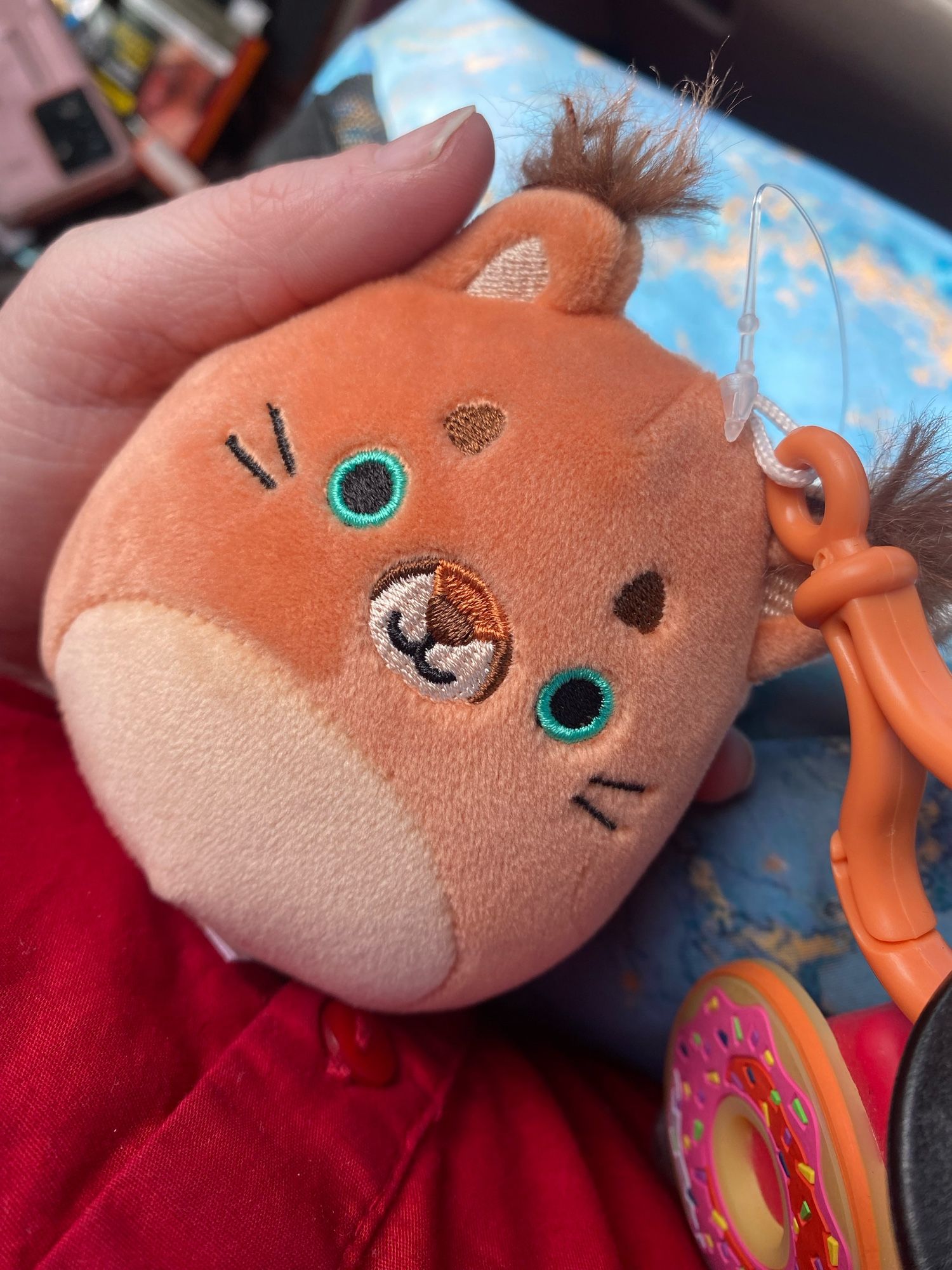 A small caracal plush in the shape of an egg. Its got cute ear tuffs and round green eyes