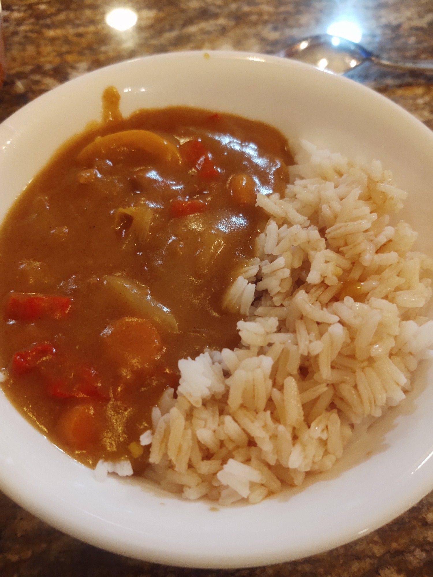 picture of "Japanese" (i think) curry and rice in a bowl together, curry has onions, peppers and carrots