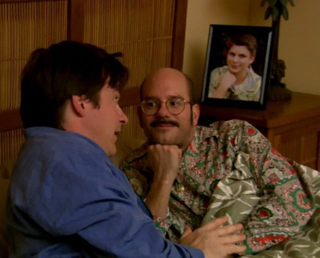 Tobias Fünke resting his chin in his hand with a framed picture of George Michael Bluth behind him doing the same pose. He [Tobias] is looking at Michael Bluth