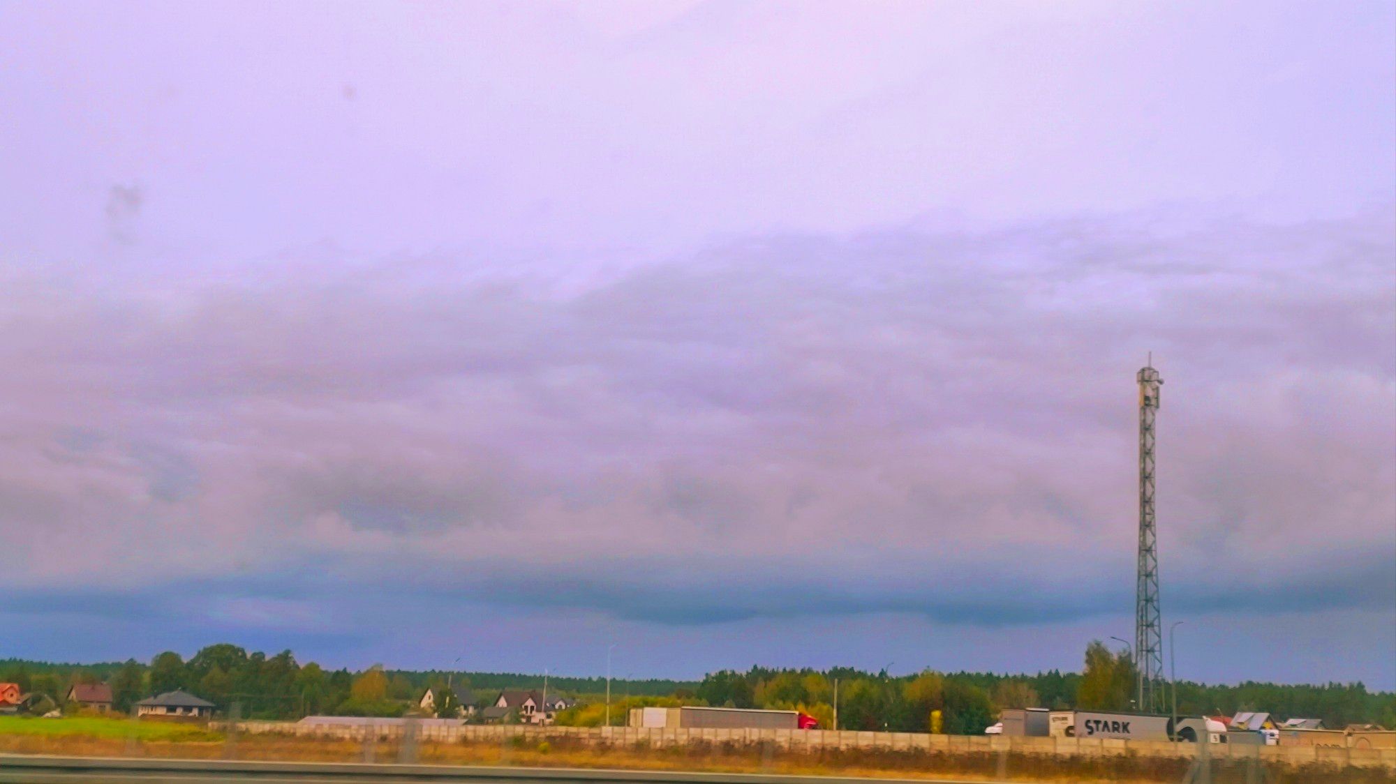 Highly saturated image of an environment with trees, houses, and trucks in the background.