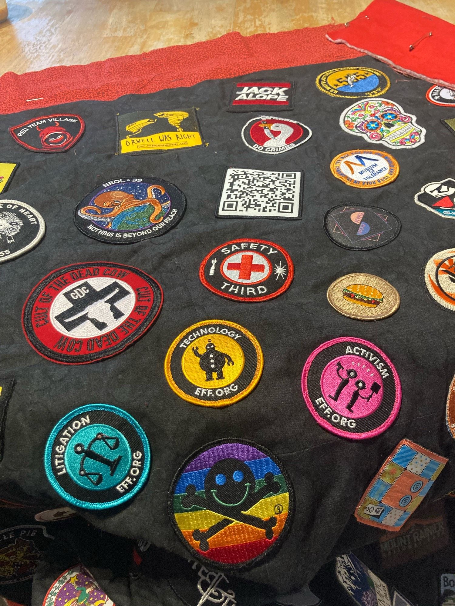 Patches on a lap quilt, detail with lots of patches from the DEFCON hacker conference