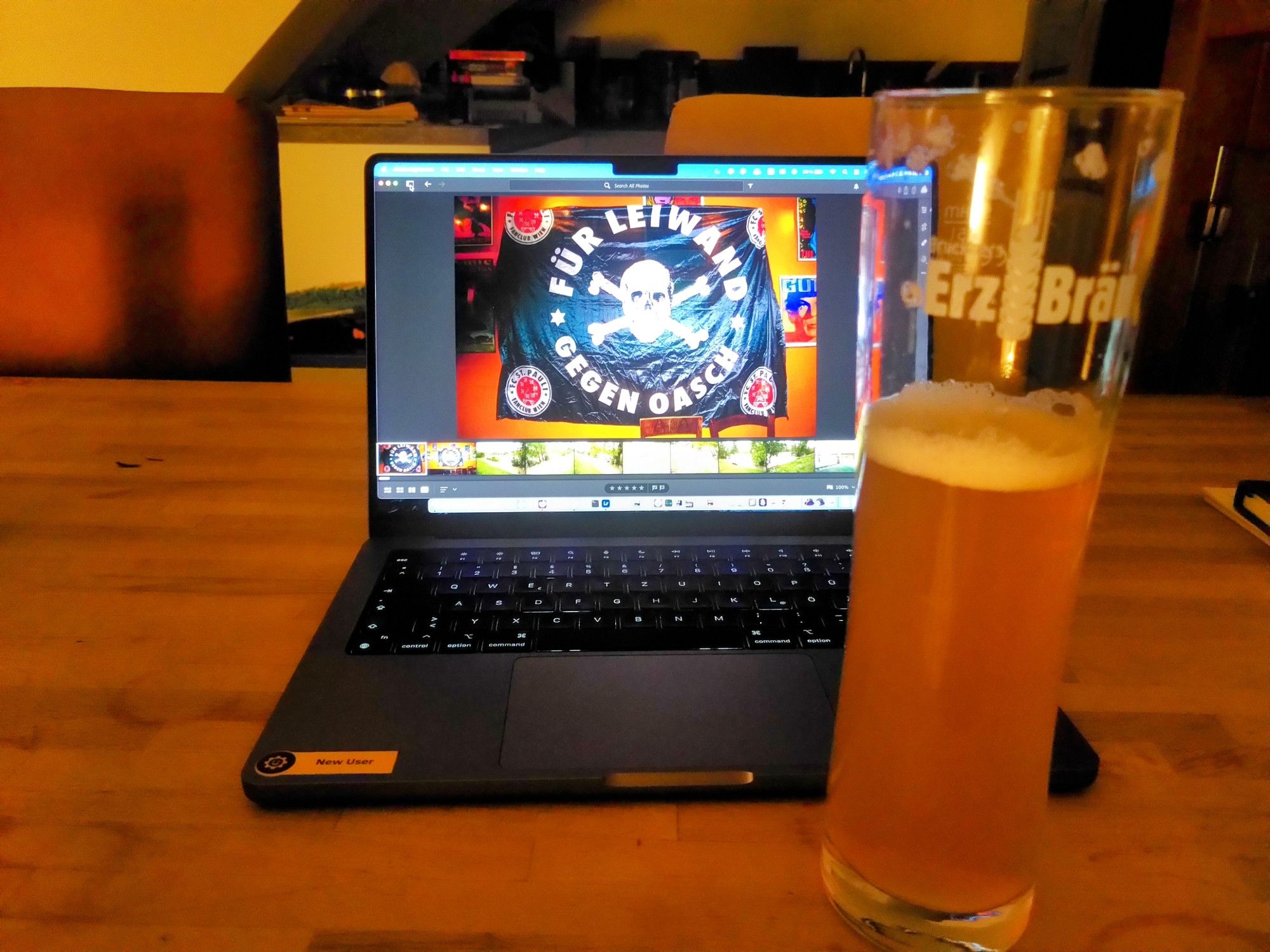 Im Vordergrund ein Glas Bier dahinter ein Computer mit Hintergrundbild, welches die Fahne des Wiener #fcsp Fanclub "Für Leiwand gegen Oasch" zeigt.