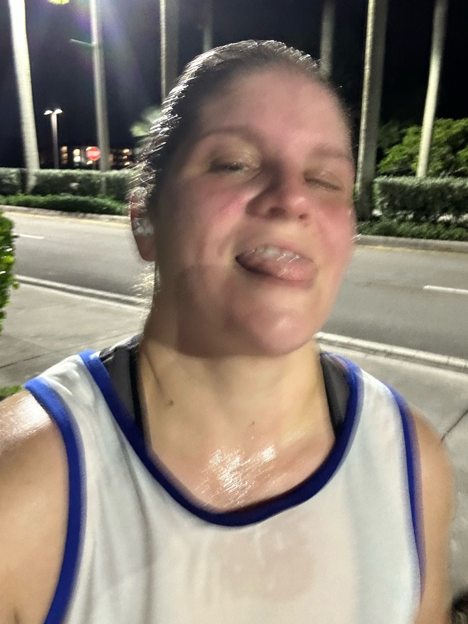 Me sweaty and blurry with my tongue slightly out. My tank top is stuck to my body