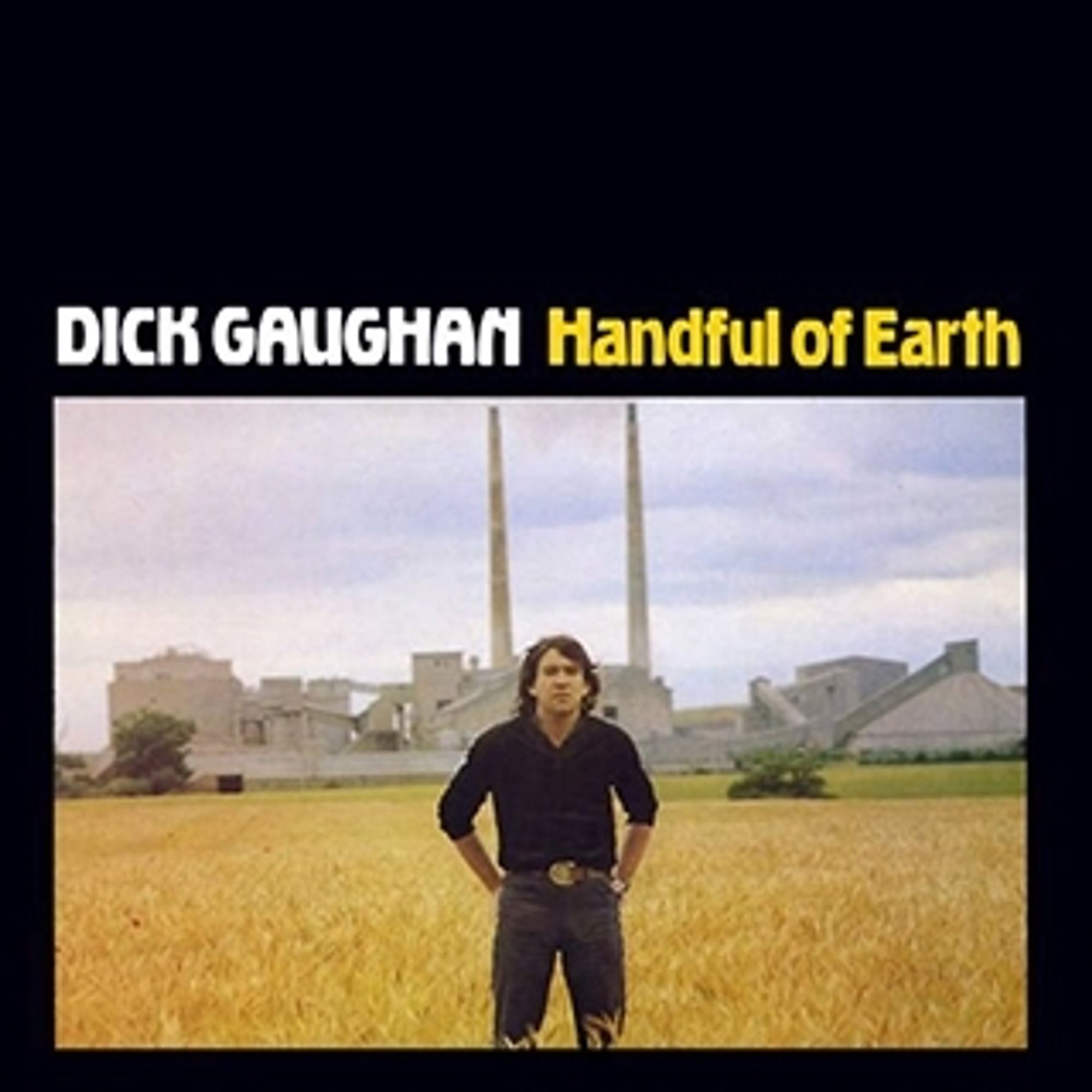 Album cover: Dick Vaughan, Handful of Earth. Photo of the artist looking quite tough, dressed in black, hands on hips, standing in a cornfield with a factory in the background