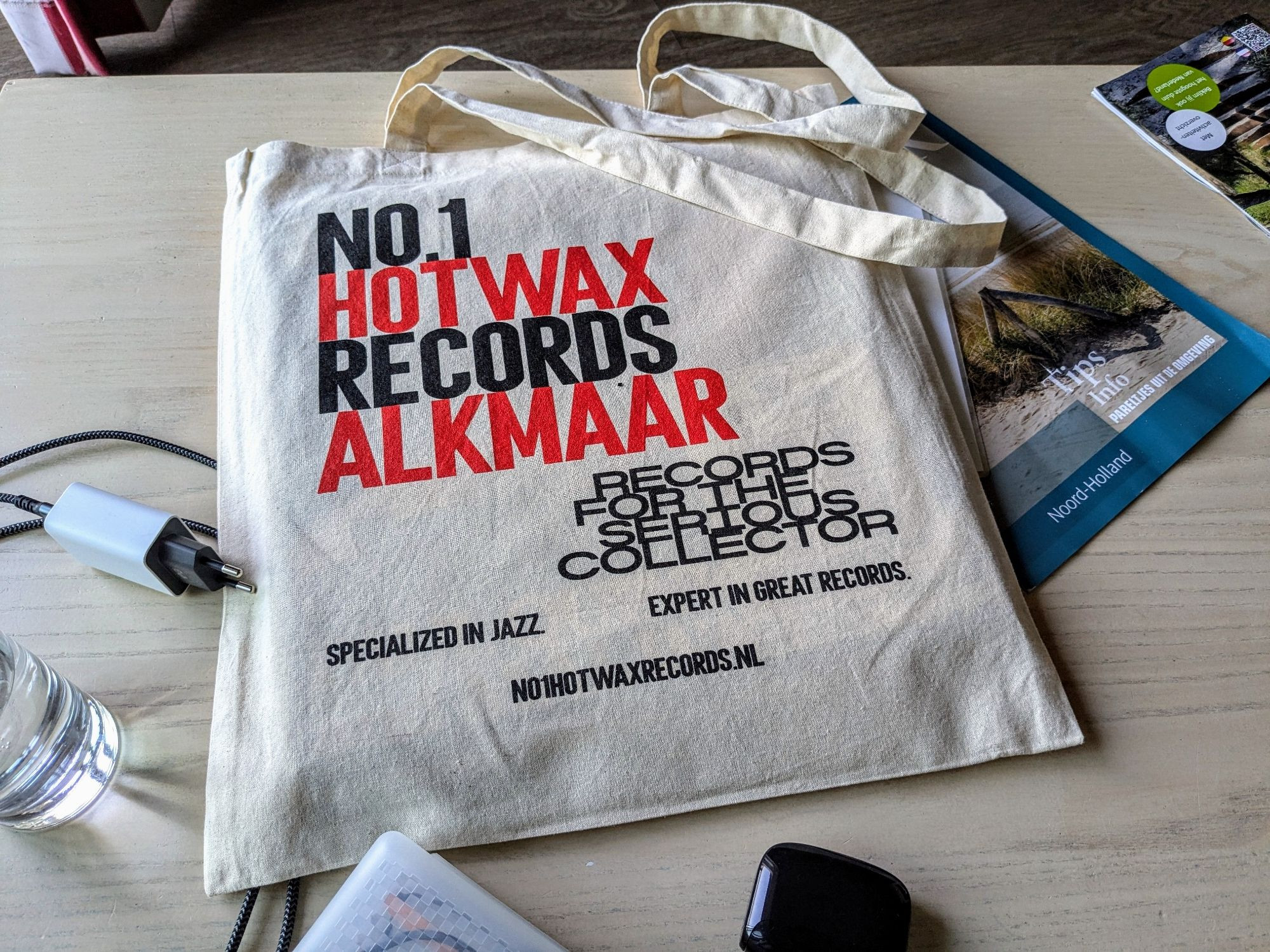 tote bag of "No.1 Hotwax Records Alkmaar -Records for the serious collector - Specialized in Jazz - Expert ingreat records" flat on a table with a handful non-visible records in it.