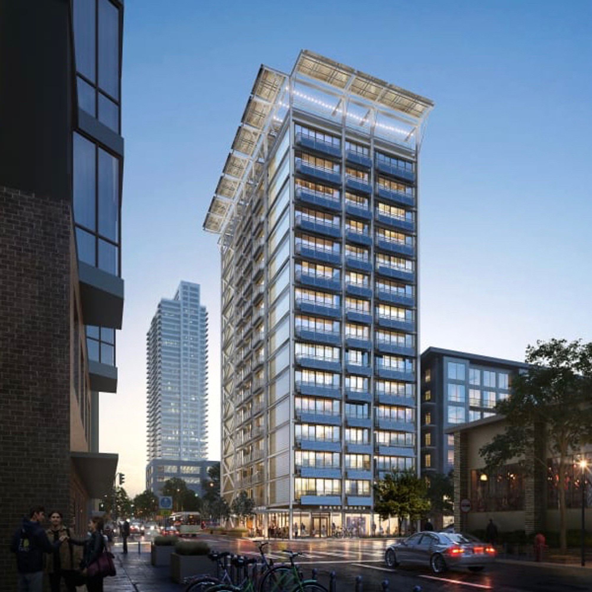 15-story apartment building in downtown Seattle has solar modules that form the guard rails of every balcony and a large solar canopy that extends out from the roof as a contemporary cornice. View from the street about a block away. Dusk lighting and a clear sky.