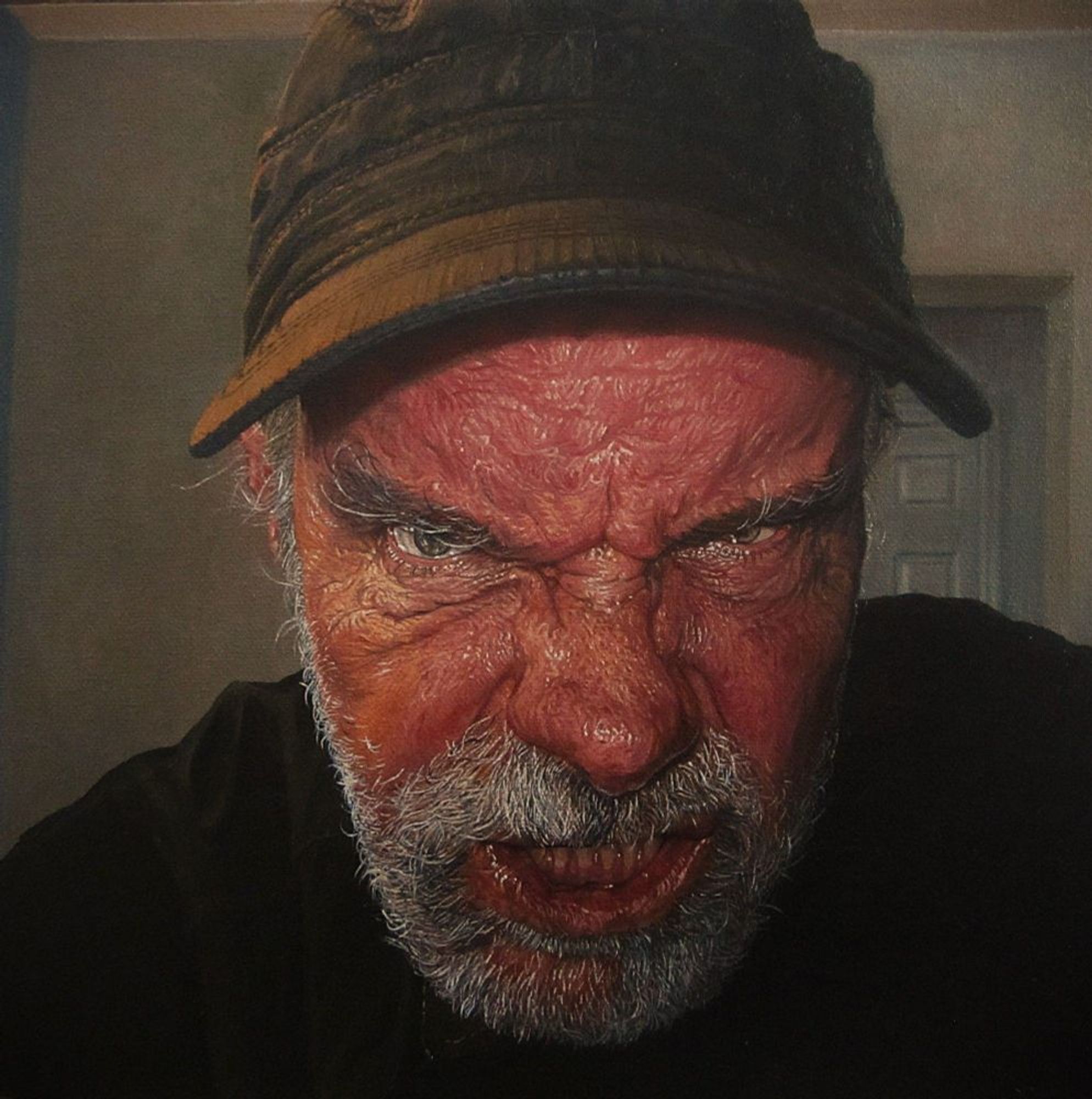 "GRRRRrrrrr", oil on canvas, 12x12", 2024- $800(Cdn). A self portrait oil painting, my face close to the picture plane, the simple interior background is in greenish putty colours. Red faced, the painting is heavily detailed depicting every wrinkle & pore. I'm glaring directly into the viewer, head forward, eyes hooded, lower teeth bared, growling. I'm wearing a black baseball & black shirt, I have a grey/white beard & moustache.