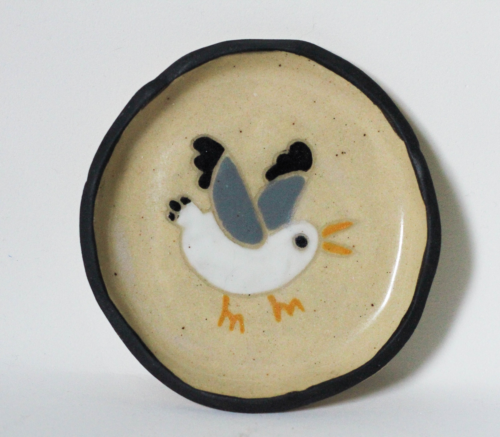 a little dish with a cartoon seagull painted on it