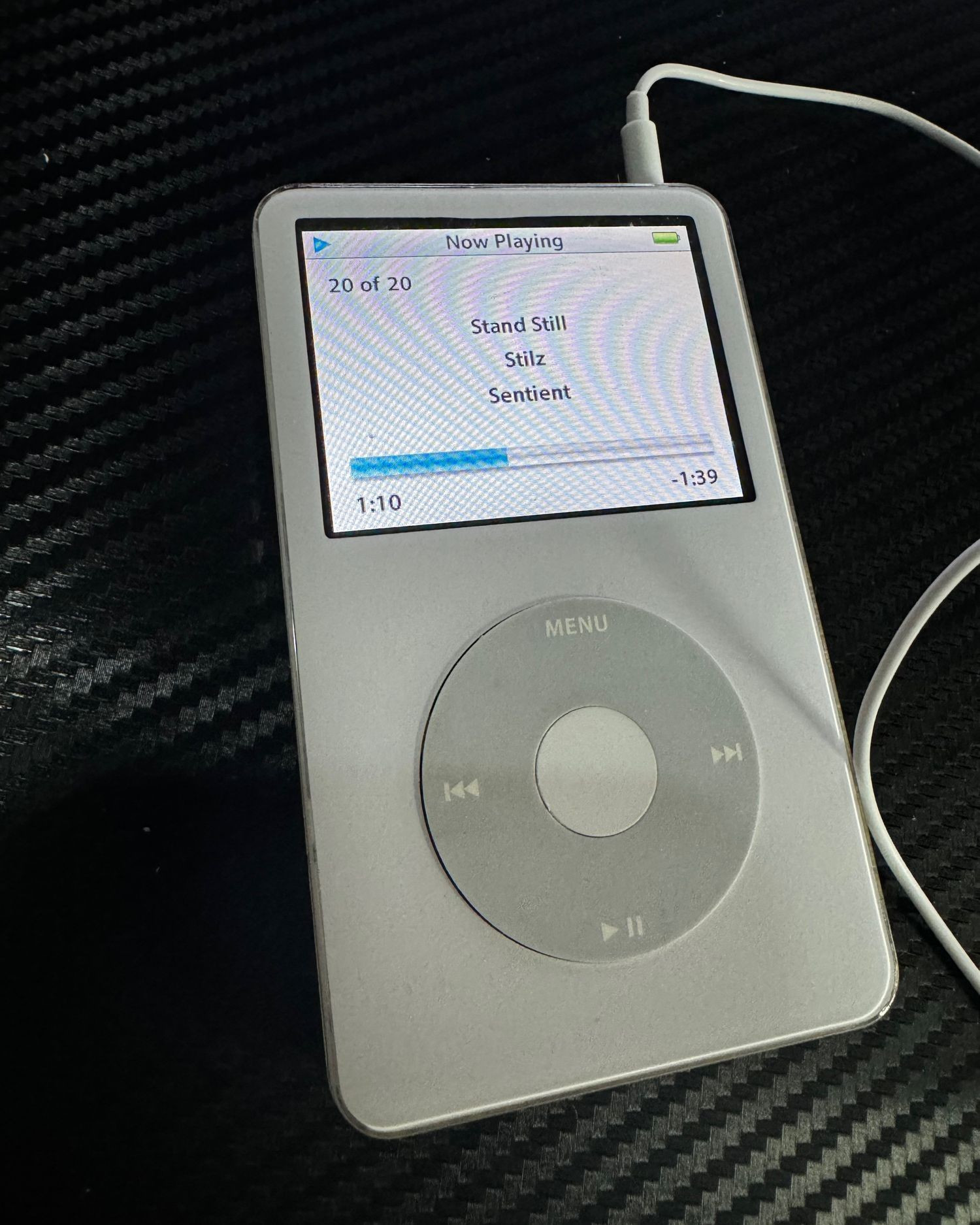 Photo of my white iPod playing the track "Stand Still" by Stilz, on-screen.