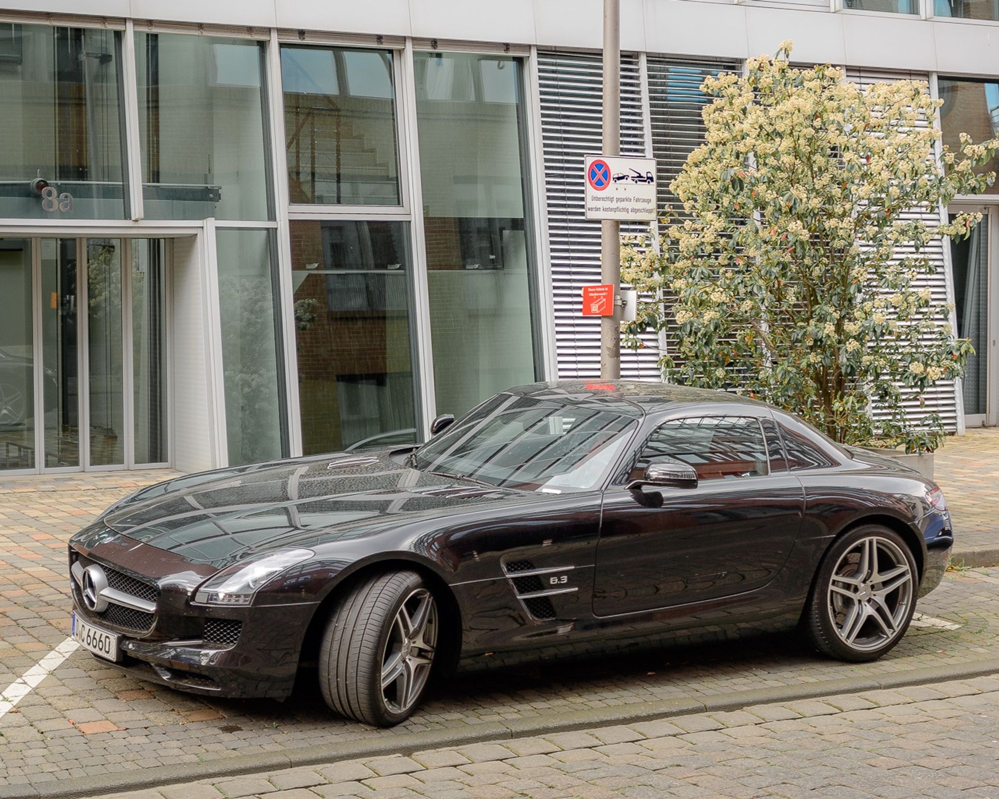 Schwarzer Mercedes-Sportwagen im Halteverbot vor einem Bürogebäude im Düsseldorfer Medienhafen.