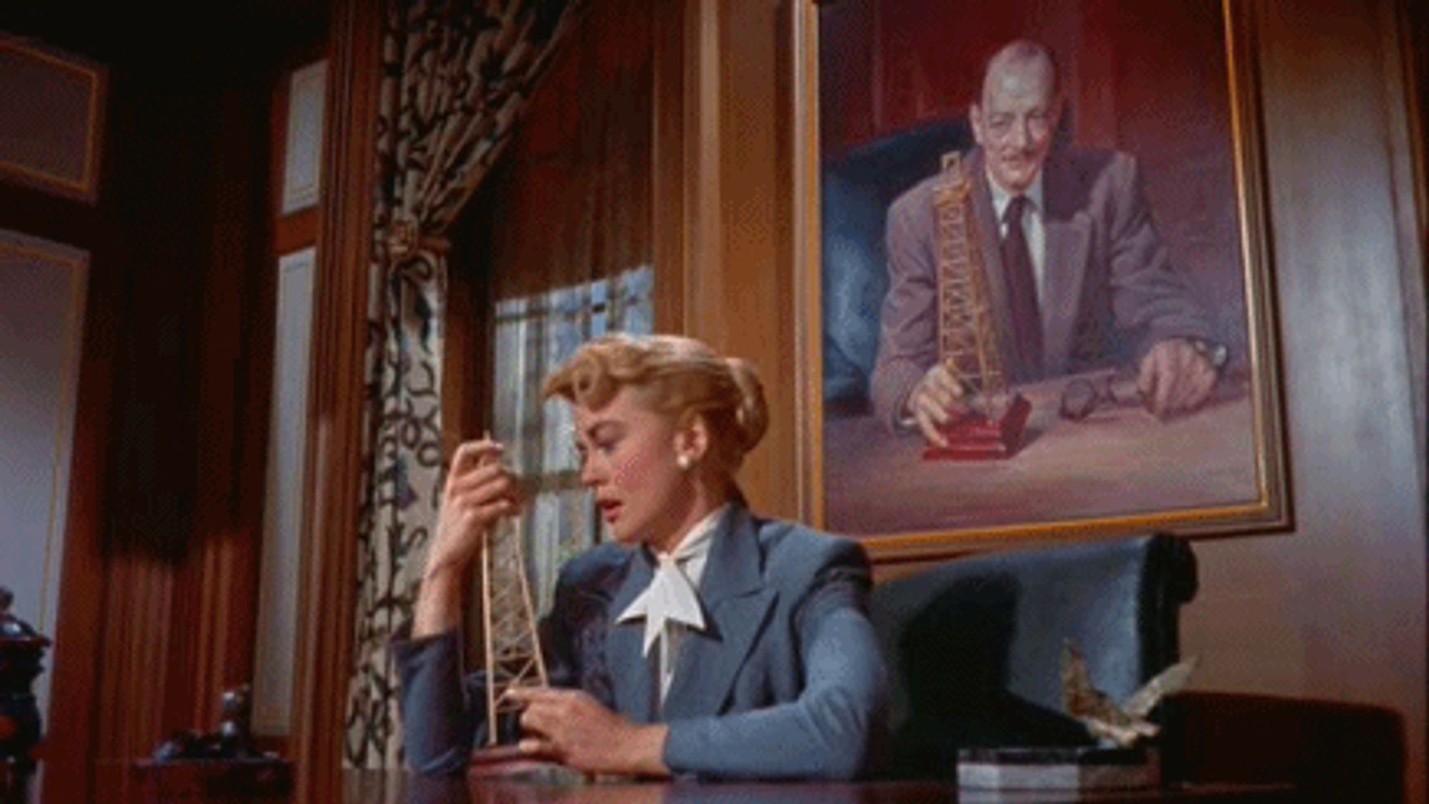 Dorothy Malone caressing a model oil rig.