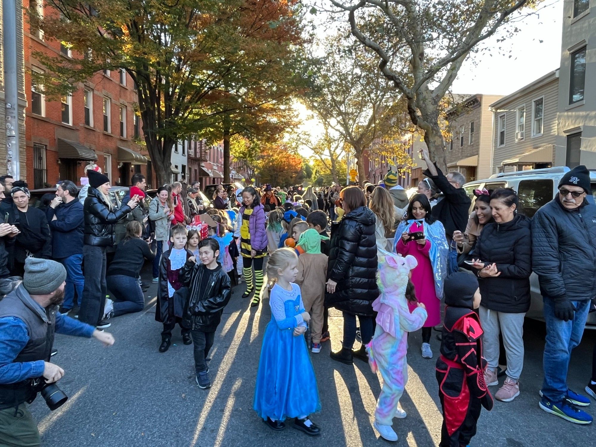 Brooklyn street filled with people. Kids are in costumes.