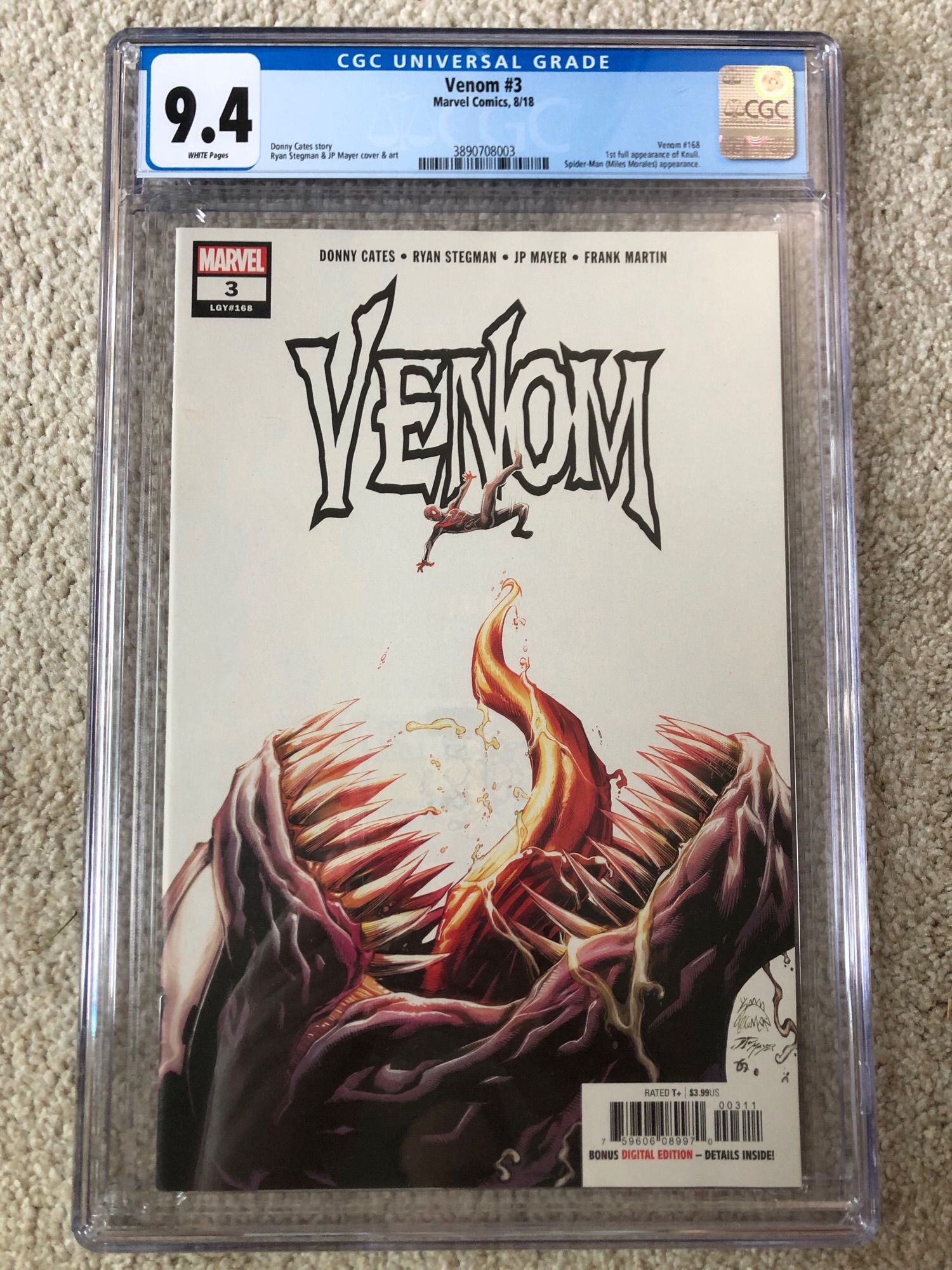 Comic book Venom (Volume 4) #3, CGC graded 9.4. Shows a Spider-Man falling into a huge dinosaur-looking mouth with sharp teeth and tongue sticking out.