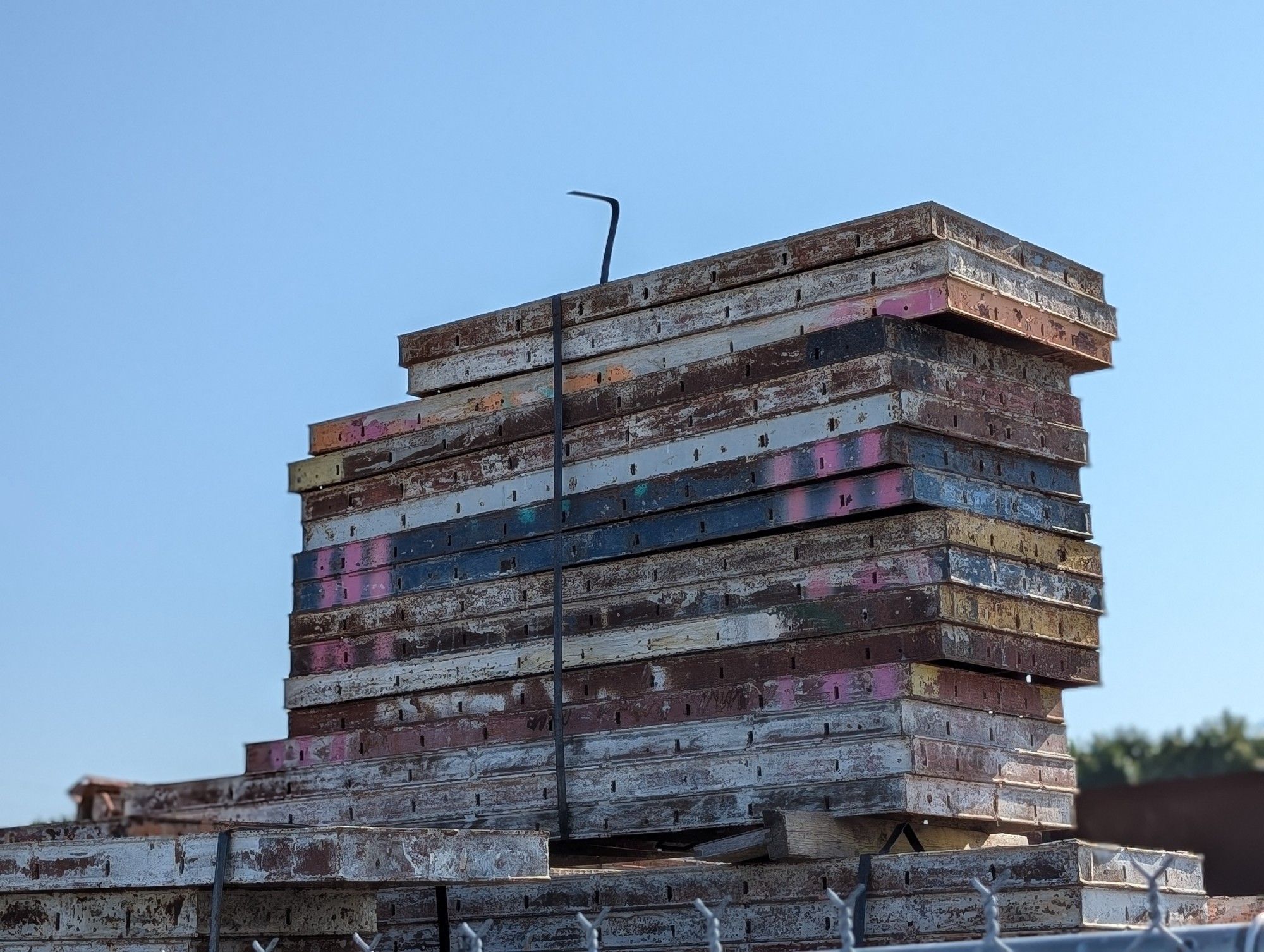 A stack of, not sure what, maybe scaffolding, with random colorful paint and rust and scratched up surfaces that all together just looks cool from this angle