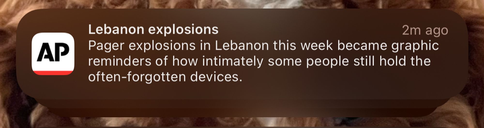 a push notification from the associated press that says “Lebanon explosions - Pager explosions in Lebanon this week became graphic reminders of how intimately some people still hold the often-forgotten devices.”