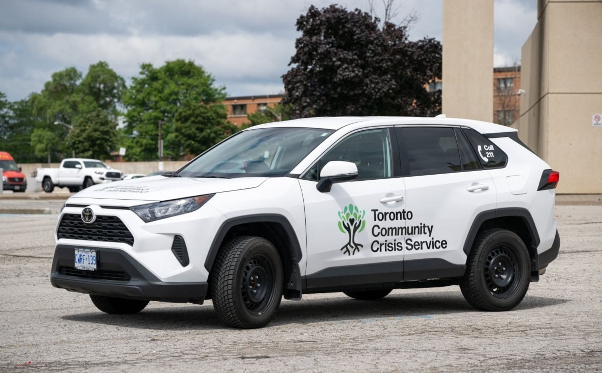 photo of a small white SUV with a logo on the side that says "Toronto Community Crisis Service"