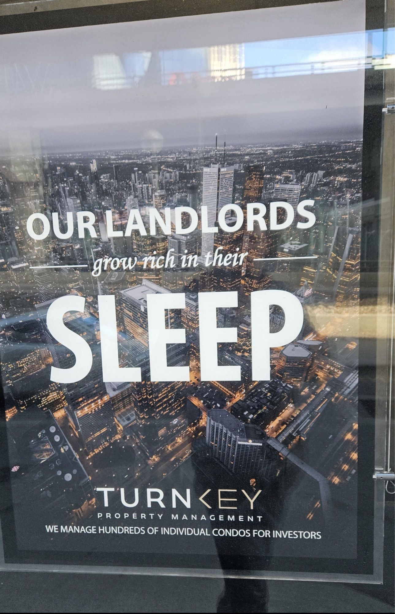 photo of a property management ad in toronto that is an aerial shot of the city with the words “our landlords grow rich in their sleep”