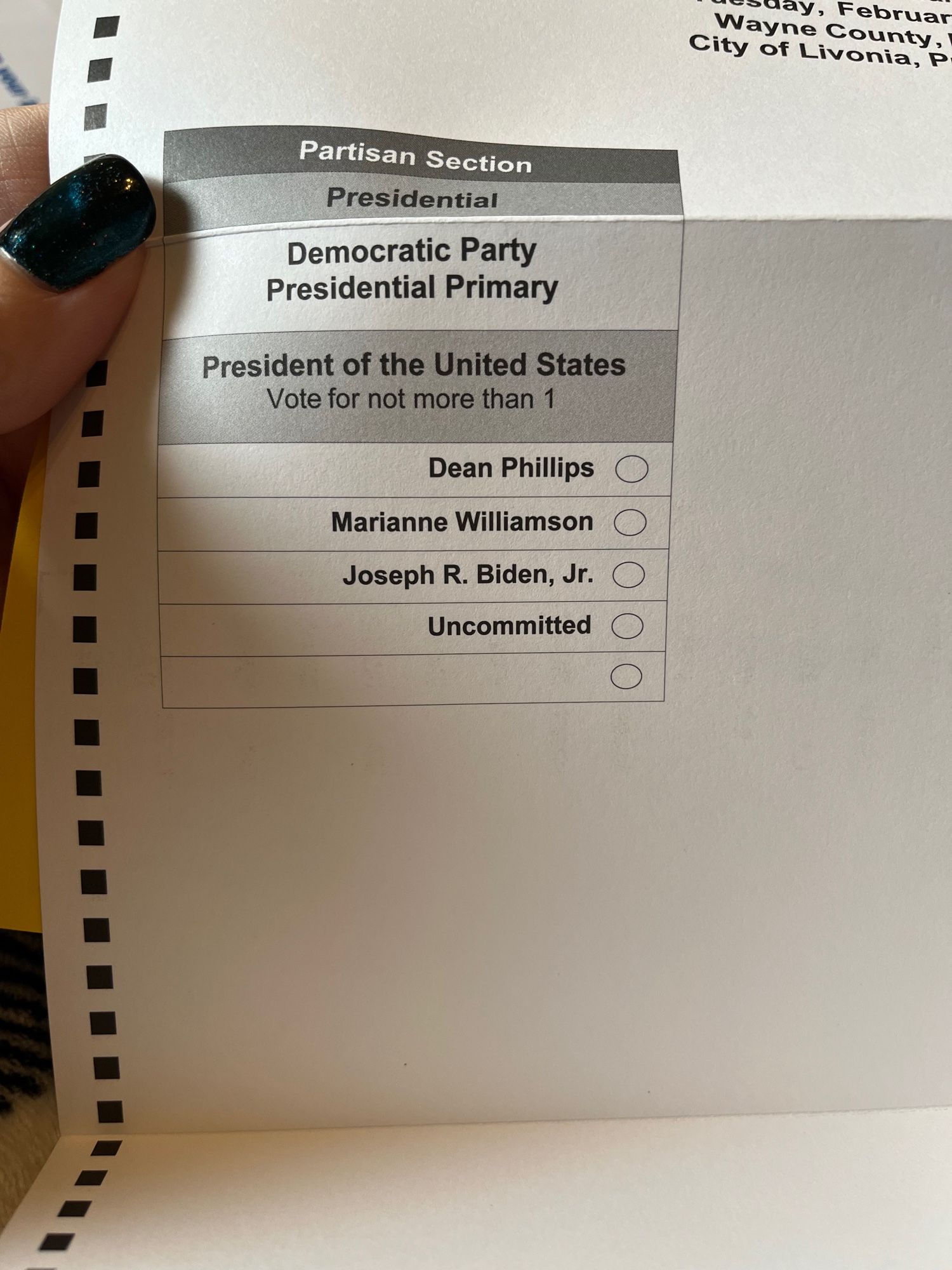 My thumb holding up my ballot for Presidential election, Democratic Party. My options are Dean Phillips, Marianna Williamson, Joseph R Biden, Jr., uncommitted, and a spot for a write in