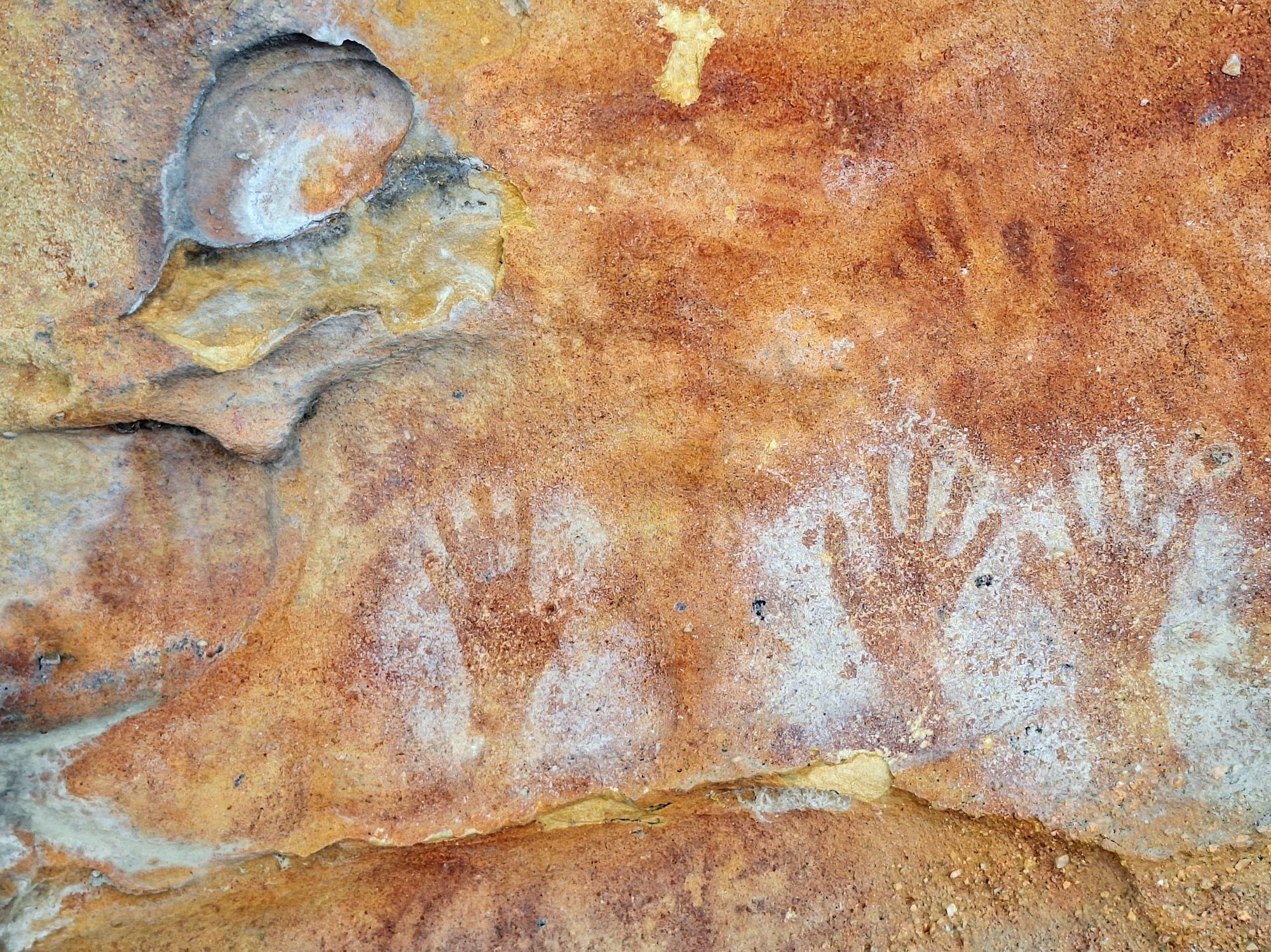 White stencil hands overlaid on red hand stencils