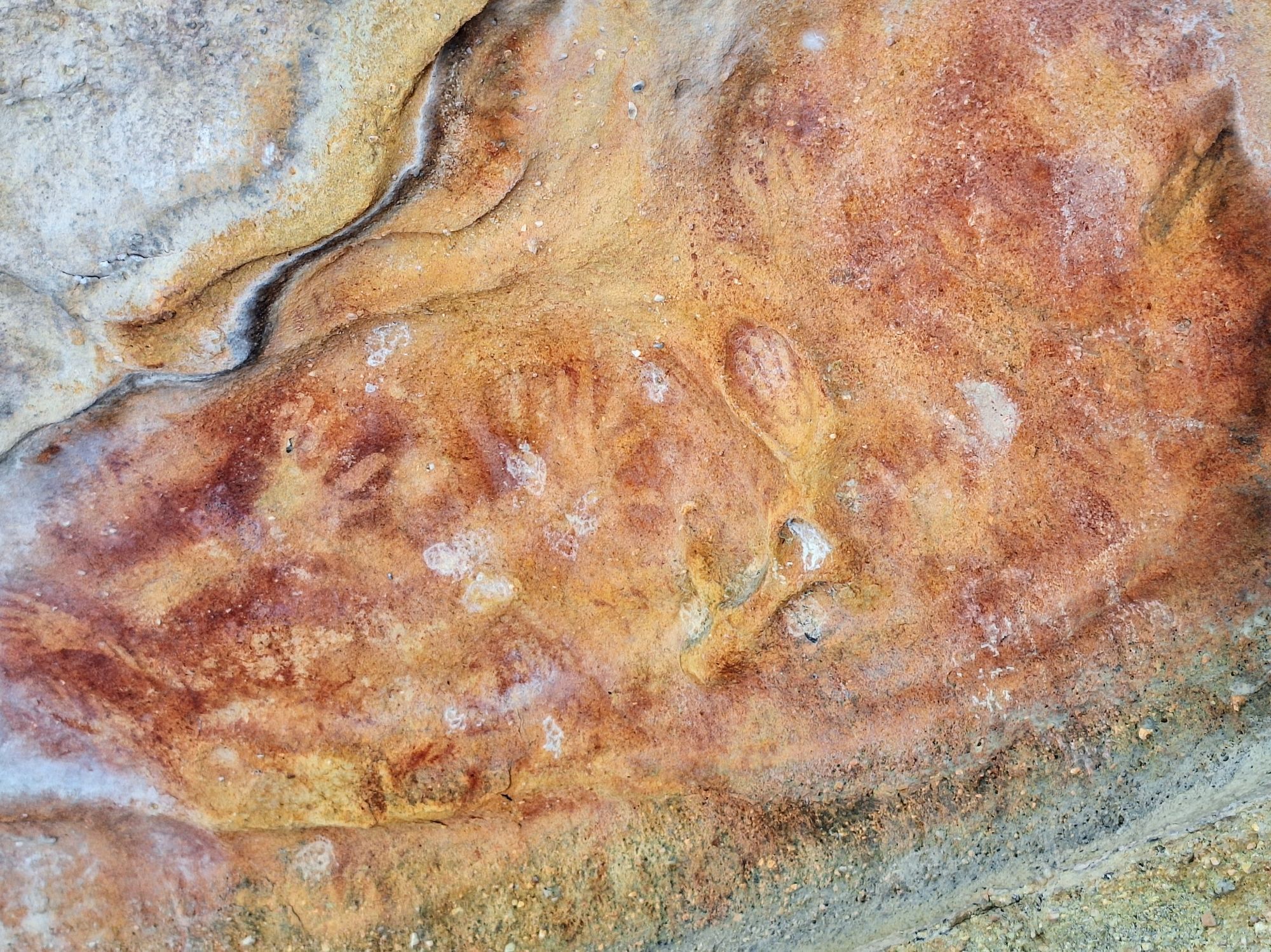 Red hand prints on the roof of a sandstone overhang