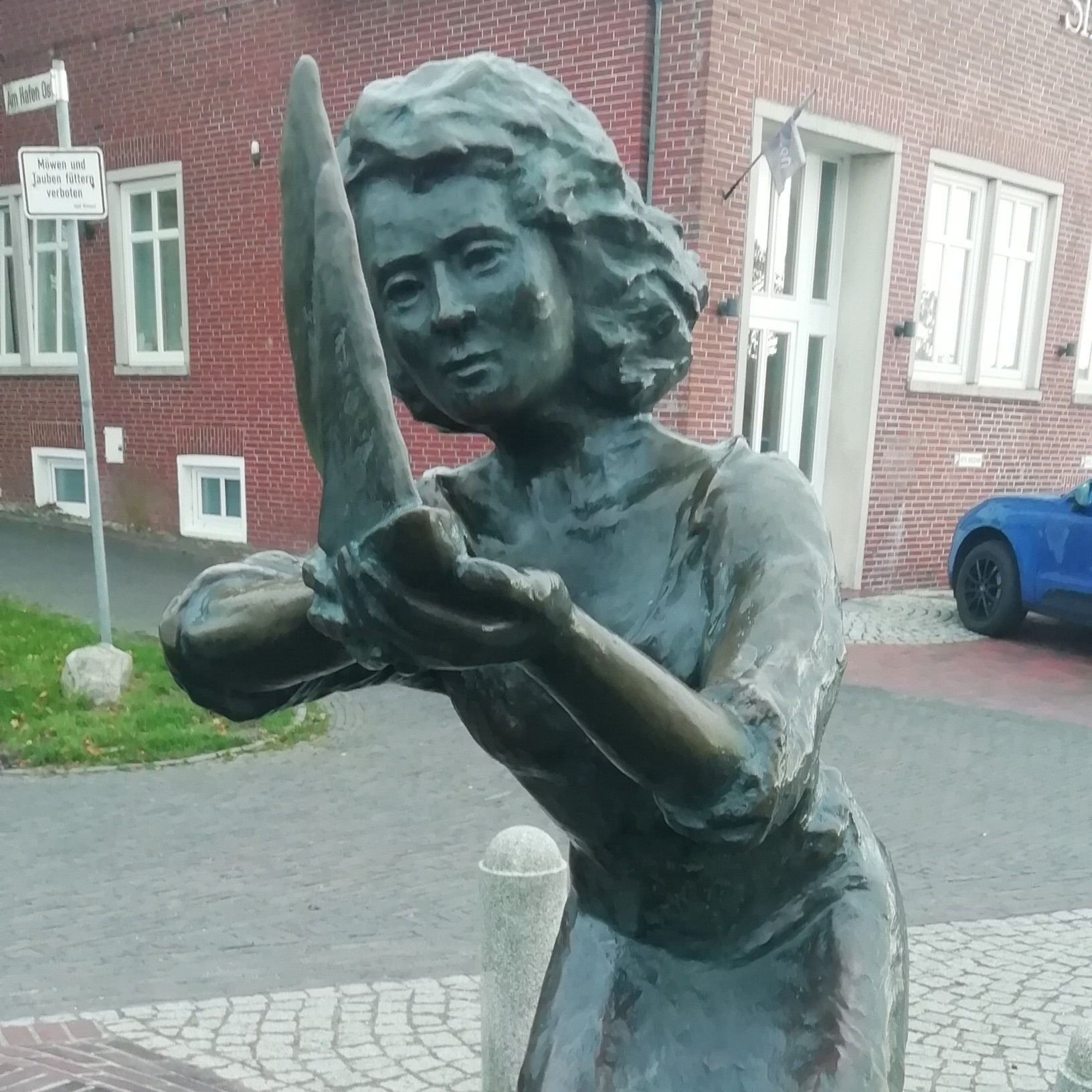 Die Caroline ist eine Bronzestatue, sie hält ein kleines Segelboot in den Händen 