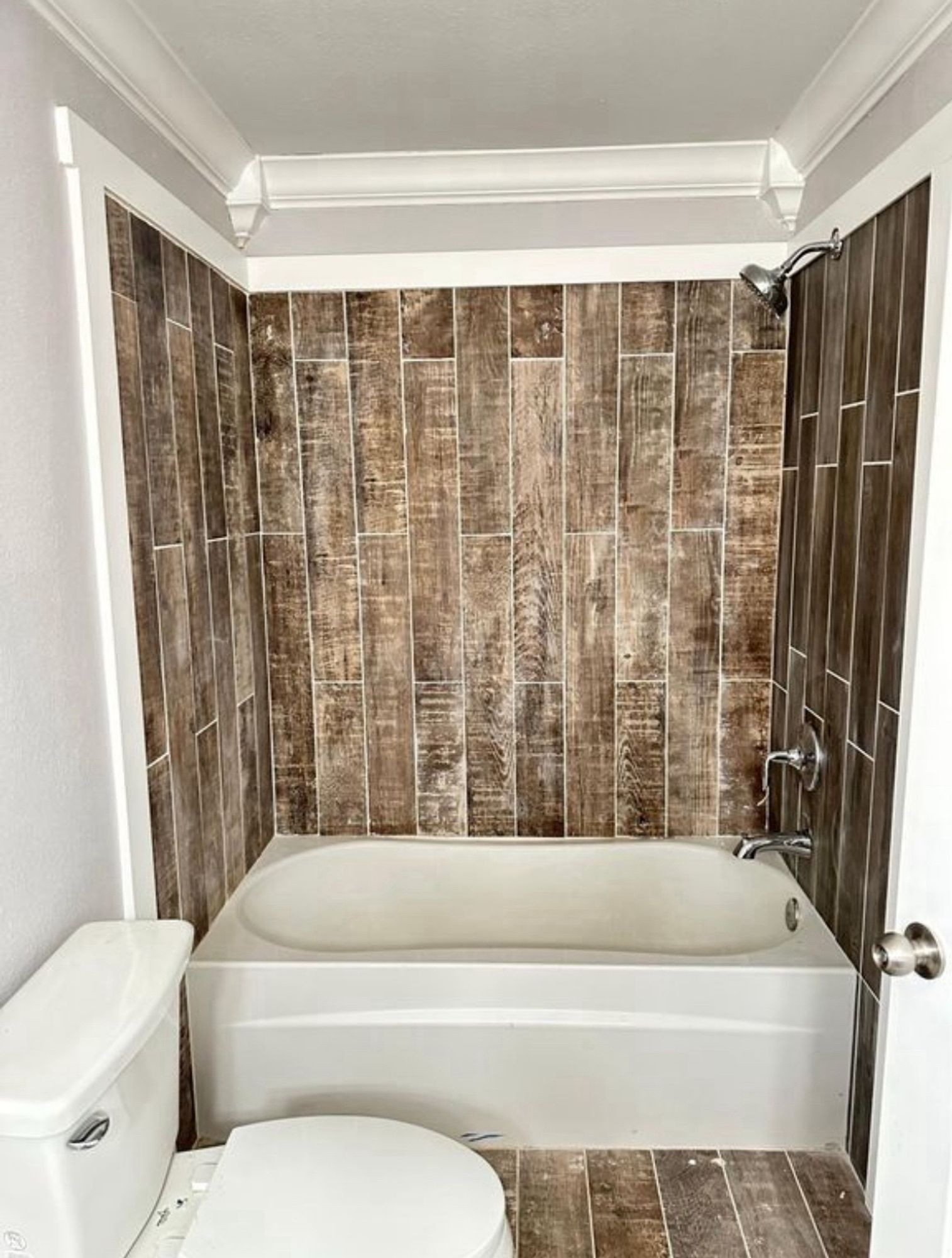 Open shower with ugly tile on the wall that matches the floor.