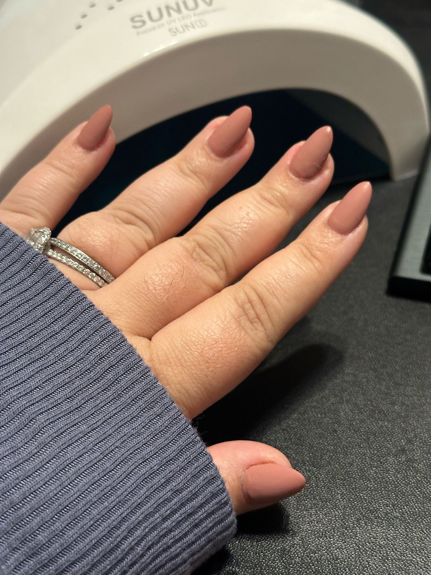 Nude matte nails in a fanned out left hand.