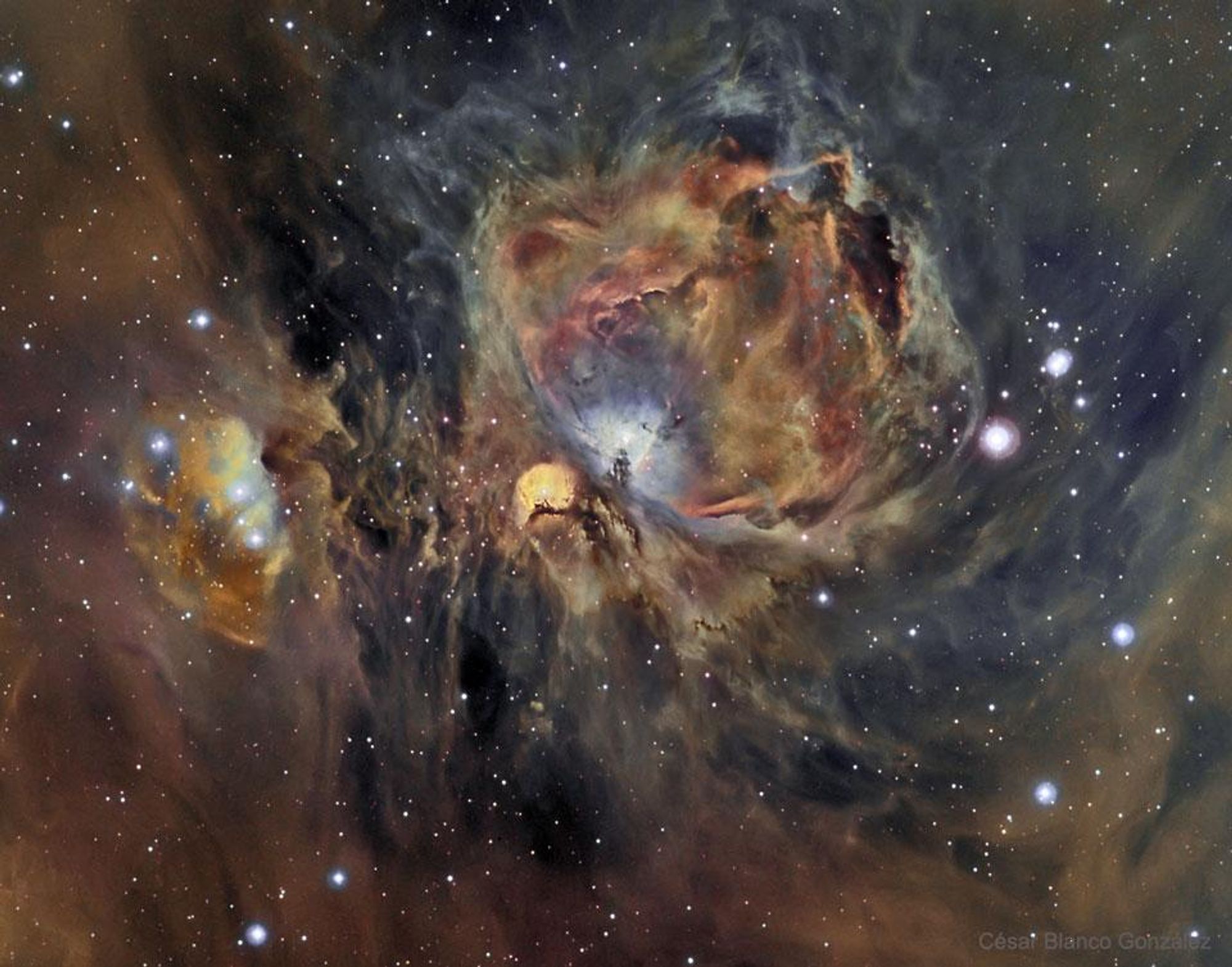 A vibrant image of the Orion Nebula, a stellar nursery where hot young stars are born amidst glowing gas and filamentary shock waves. The image showcases the nebula's intricate structures, captured in three colors representing hydrogen, oxygen, and sulfur gas. The Orion Nebula spans about 40 light years and is located about 1500 light years away.