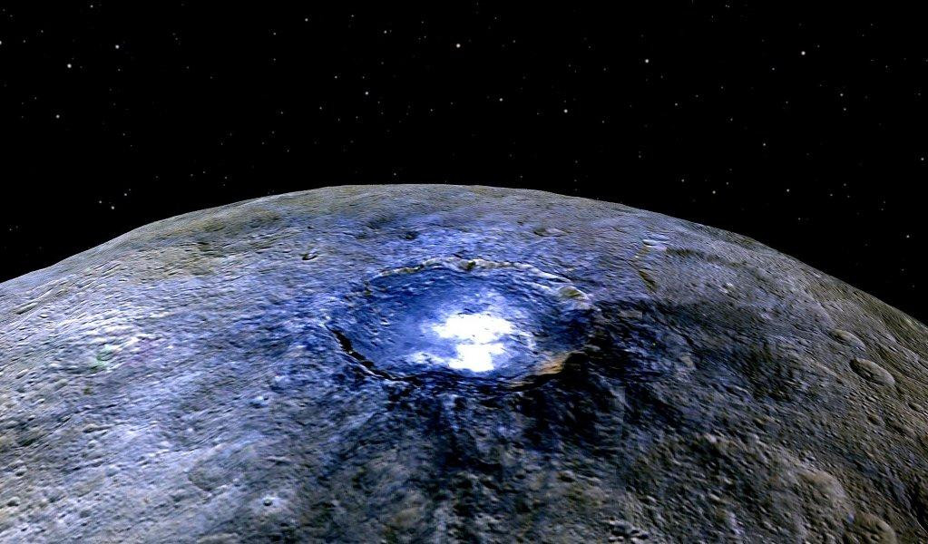 A false-color image of Ceres, the largest object in the asteroid belt, showing a bright spot near the center of the 90-kilometer-wide Occator Crater. The bright spot is thought to be made of hexahydrite, a type of magnesium sulfate also known as Epsom salt.