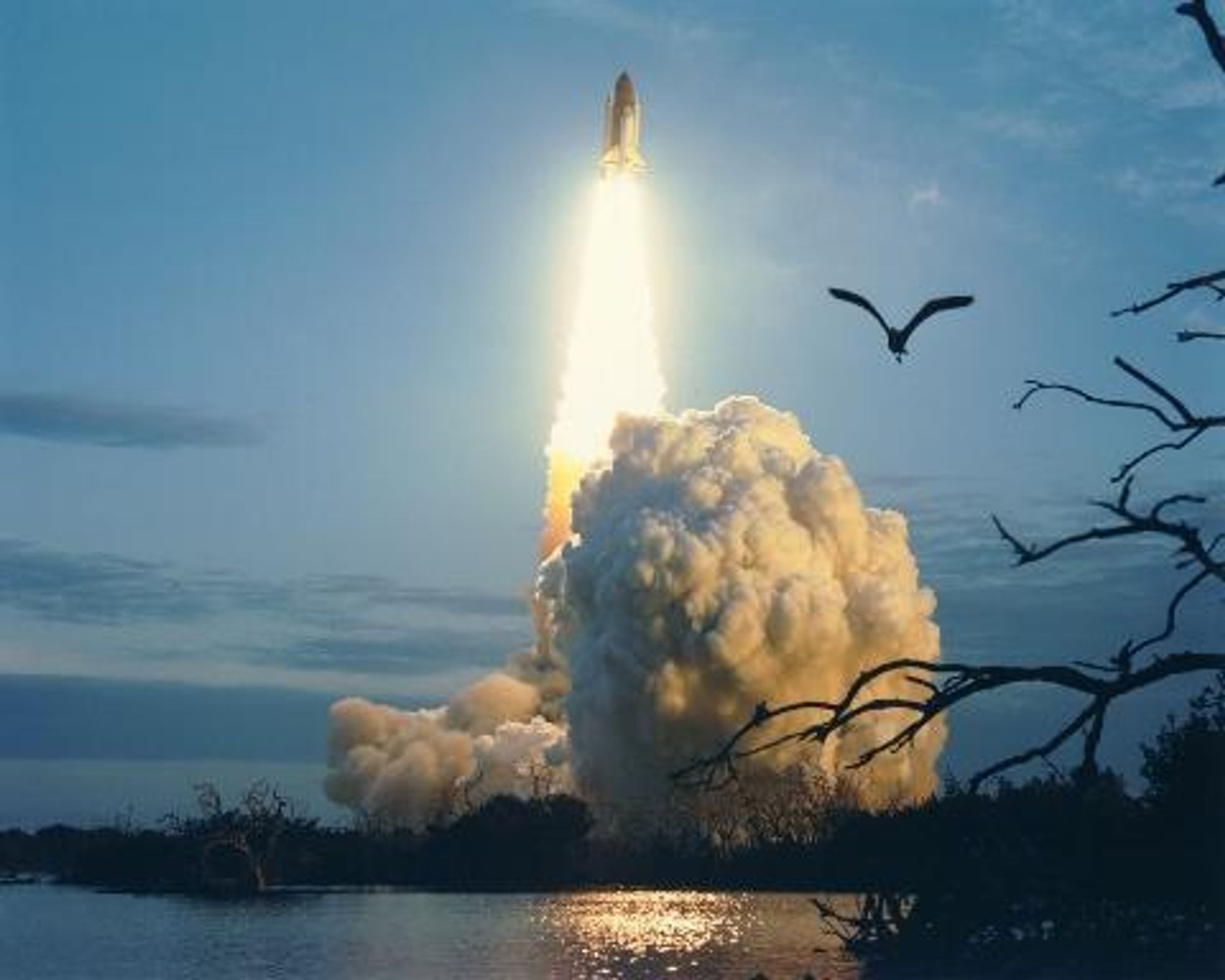 The Space Shuttle Columbia ascends into the morning sky over Florida, leaving a trail of smoke and fire as it lifts off from Kennedy Space Center's Launch Complex 39-A.  This photo was taken in January 1996, as the shuttle prepares for its STS-80 mission.