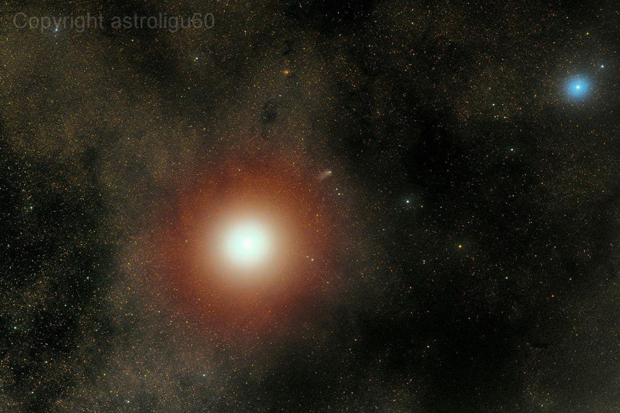 A telescopic image of Mars, taken the day after Comet Siding Spring passed by the Red Planet on October 20, 2014. The comet is emerging from Mars's bright glare and is just visible as a faint, elongated blur near the center of the image. The bright blue star 51 Ophiuchi is at the upper right of the image, and the star field is part of the constellation Ophiuchus.