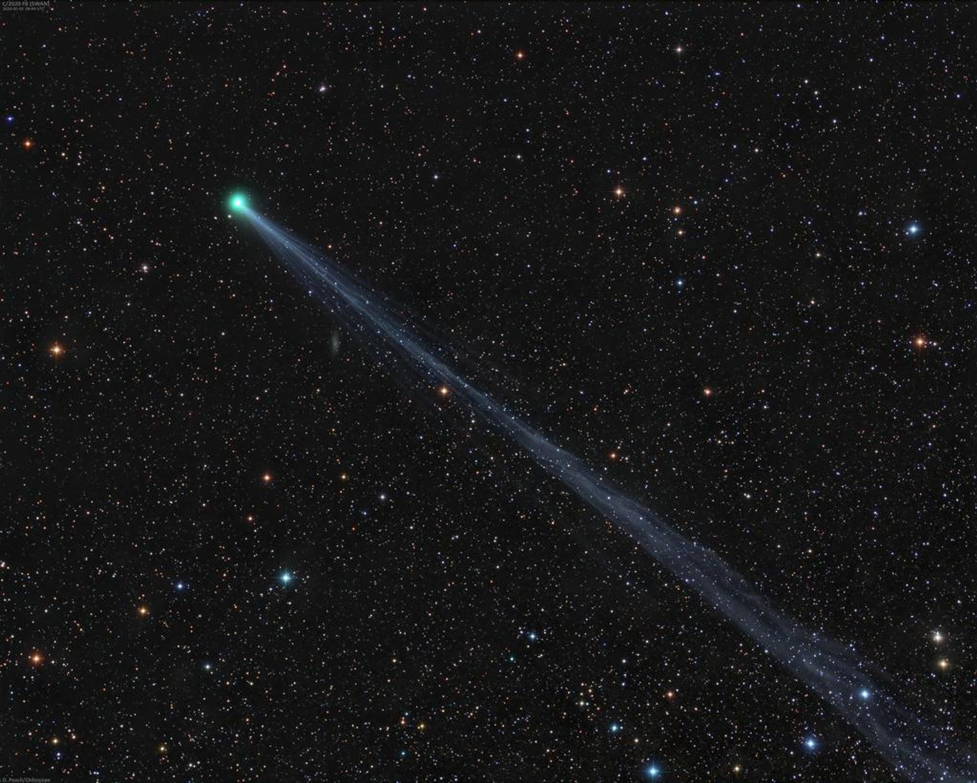 A telephoto image of Comet SWAN (C/2020 F8) with its greenish coma and long ion tail stretching across a starfield near the constellations Cetus and Aquarius. The comet was discovered by Australian amateur astronomer Michael Mattiazzo using images from the SOHO spacecraft's SWAN camera.  The comet is now visible to the naked eye in the morning twilight near the eastern horizon.