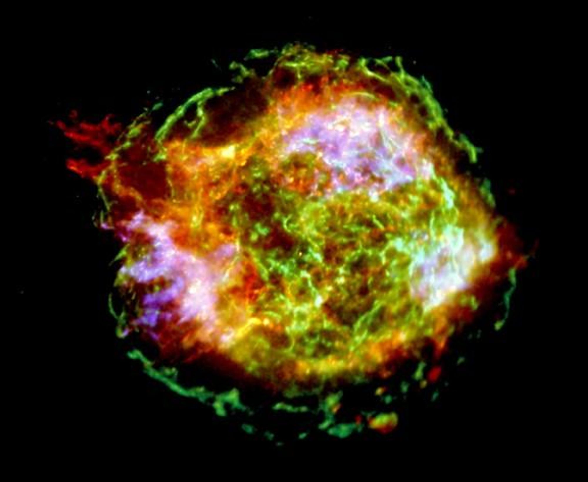 A stunning false-color image of supernova remnant Cassiopeia A, captured by the Chandra Observatory. The green outer ring, marking the expanding shock wave from the original explosion, is 10 light-years across. A structure extending beyond the ring suggests energetic jets from the initial explosion. At the center, a tiny point of light is the neutron star, the collapsed core of the exploded star.  The image was created using one million seconds of X-ray data.