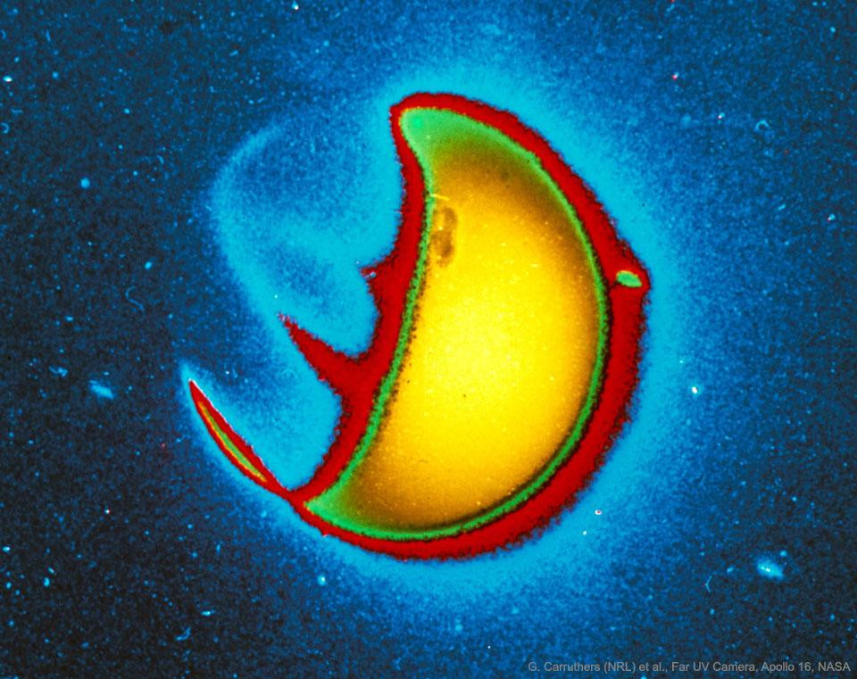 A false-color image of Earth in ultraviolet light, taken from the surface of the Moon by the first lunar observatory. The bright yellow area is Earth's sunlit side reflecting UV light. The red and green bands on the side facing away from the Sun are auroras caused by charged particles from the Sun.