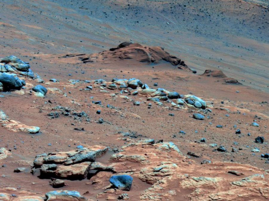 A color-enhanced image of the Martian surface taken by the Spirit rover showing the Comanche Outcrop, a rock formation containing high levels of magnesium iron carbonate, which indicates that water might once have flowed across Mars.