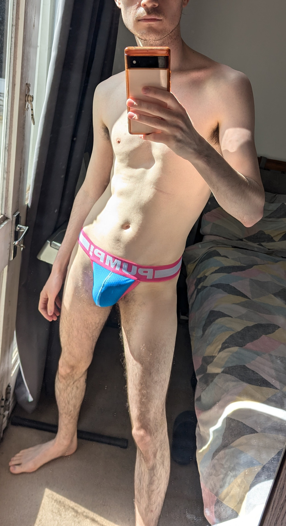 mirror selfie of me in a blue and pink pump thong, bulge view