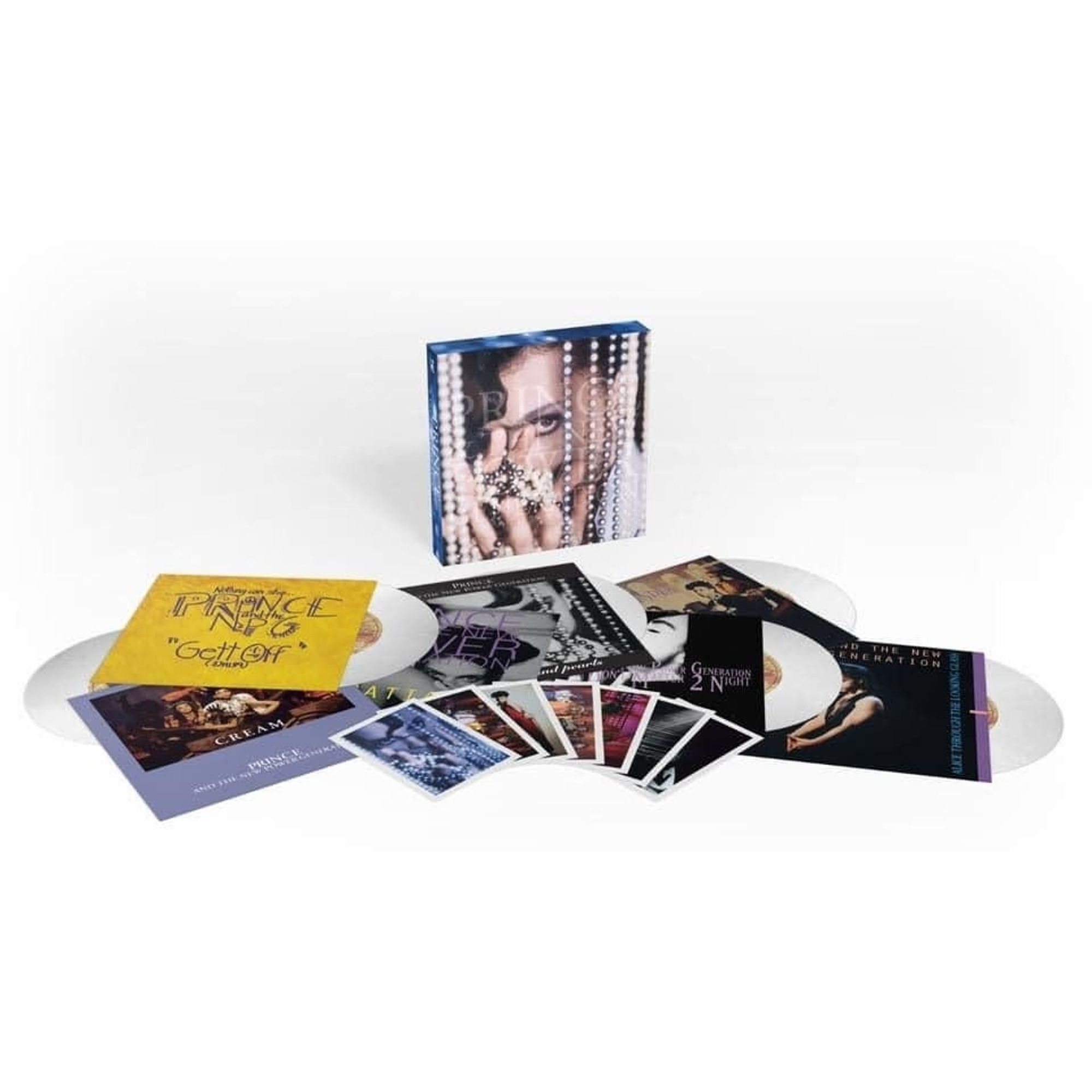 A leaked photo of a Diamonds and Pearls 7" single box set by Prince.  The photo shows 6 pearl coloured 7" vinyl with 7 postcards all enclosed in box with prince peering through strings of pearls.